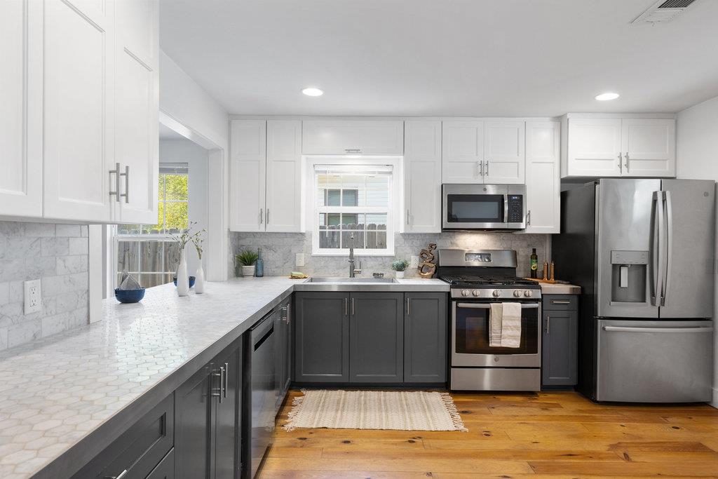 Kitchen featuring white cabinets, appliances with