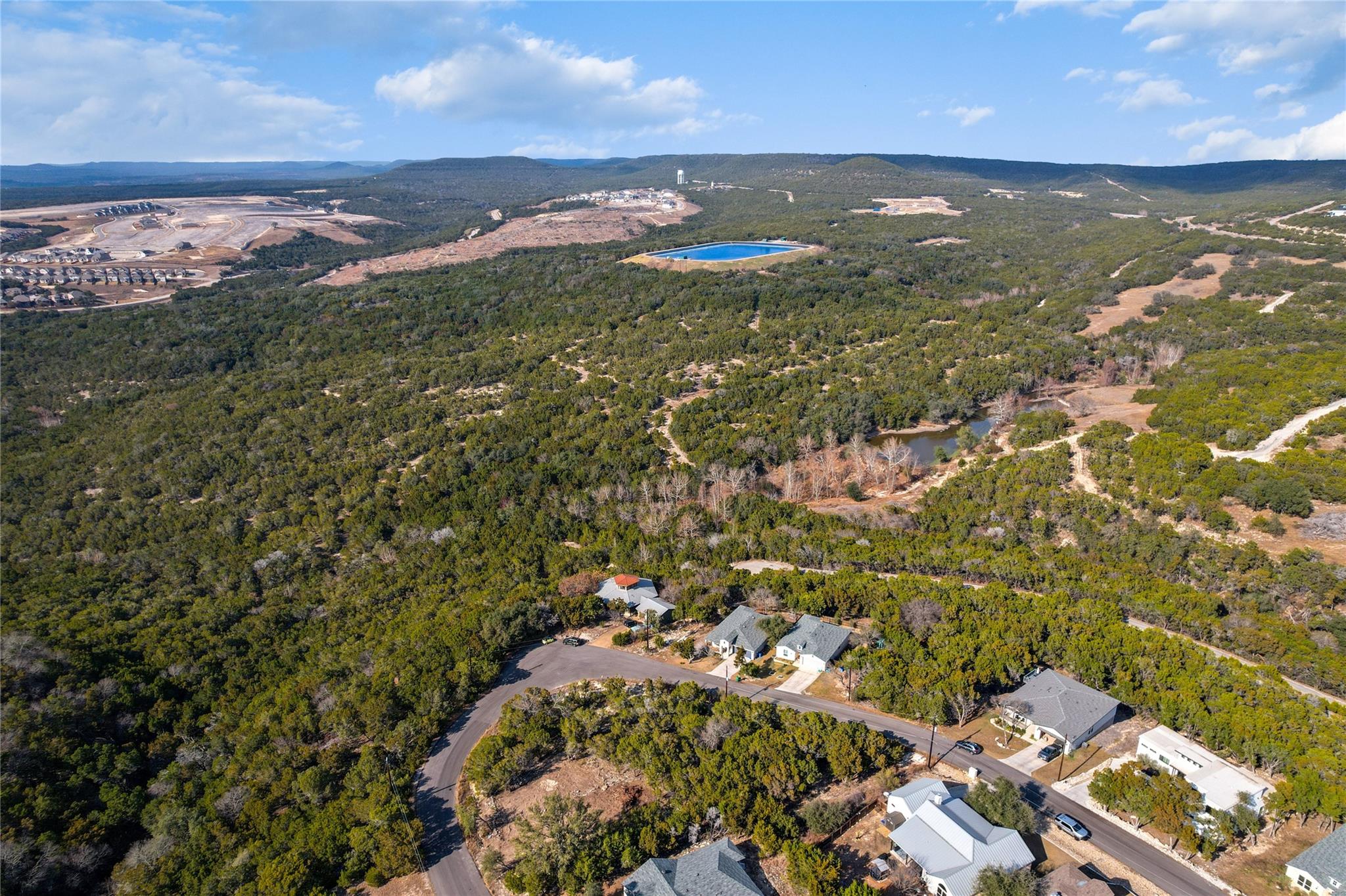 View of property location with a heavily wooded a