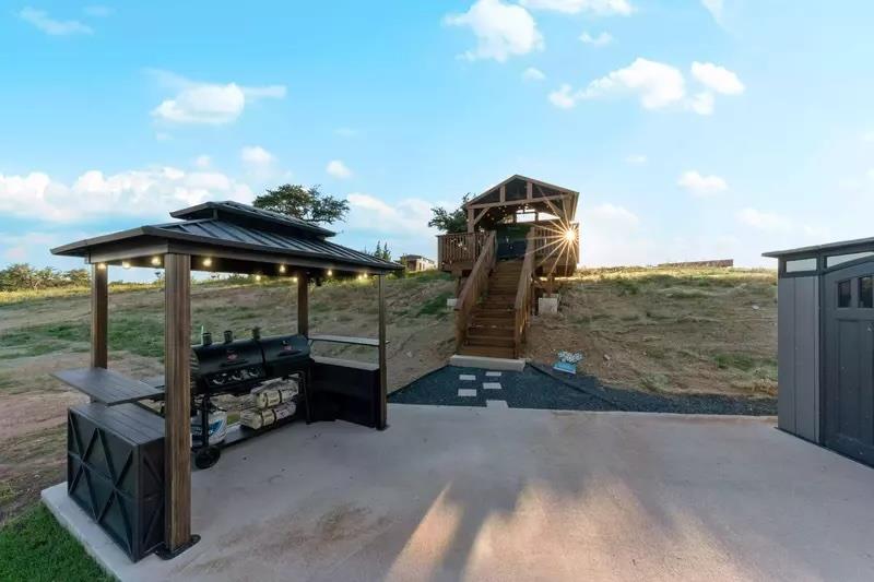 View of patio with a gazebo and stairway
