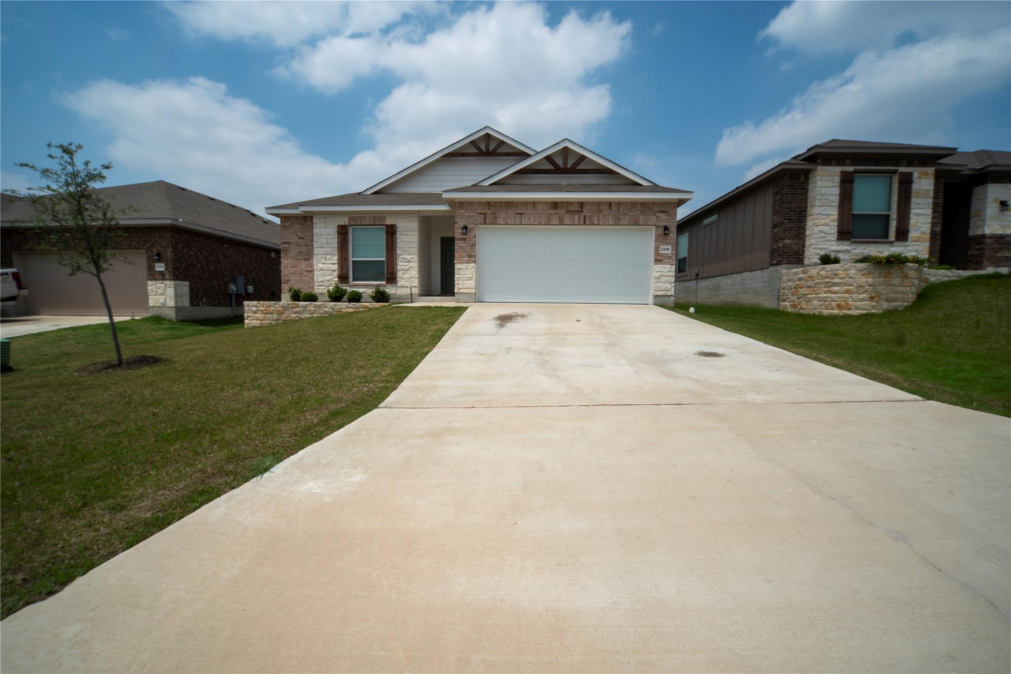 Ranch-style house with a front lawn, stone siding