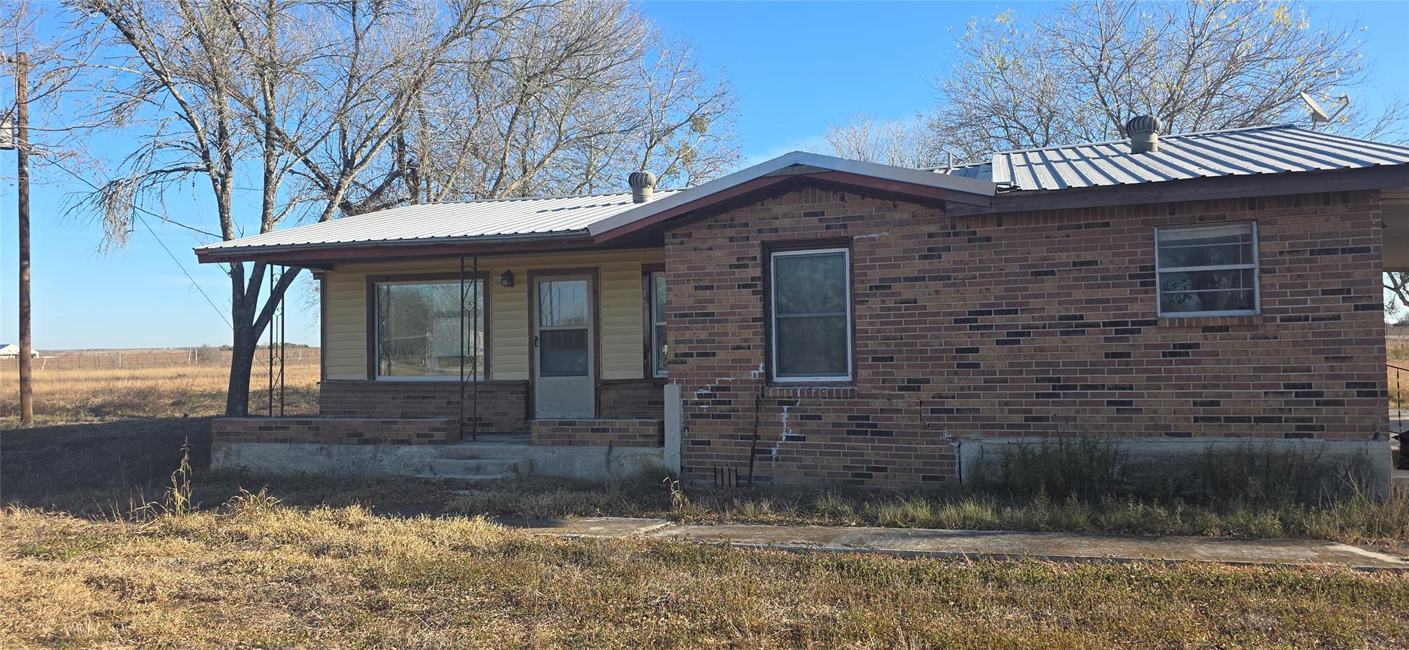 View of home's exterior with a metal roof, a porc
