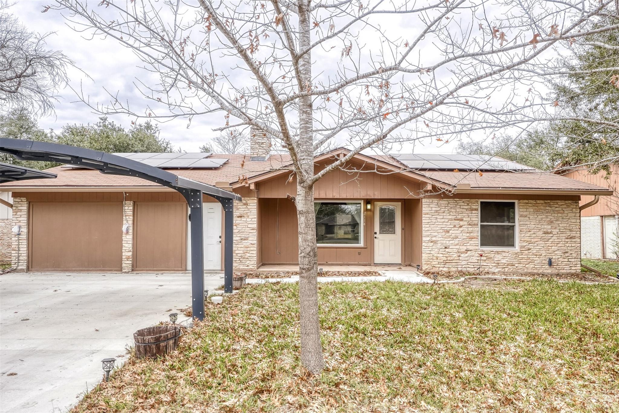 Ranch-style home with stone siding, a front yard,