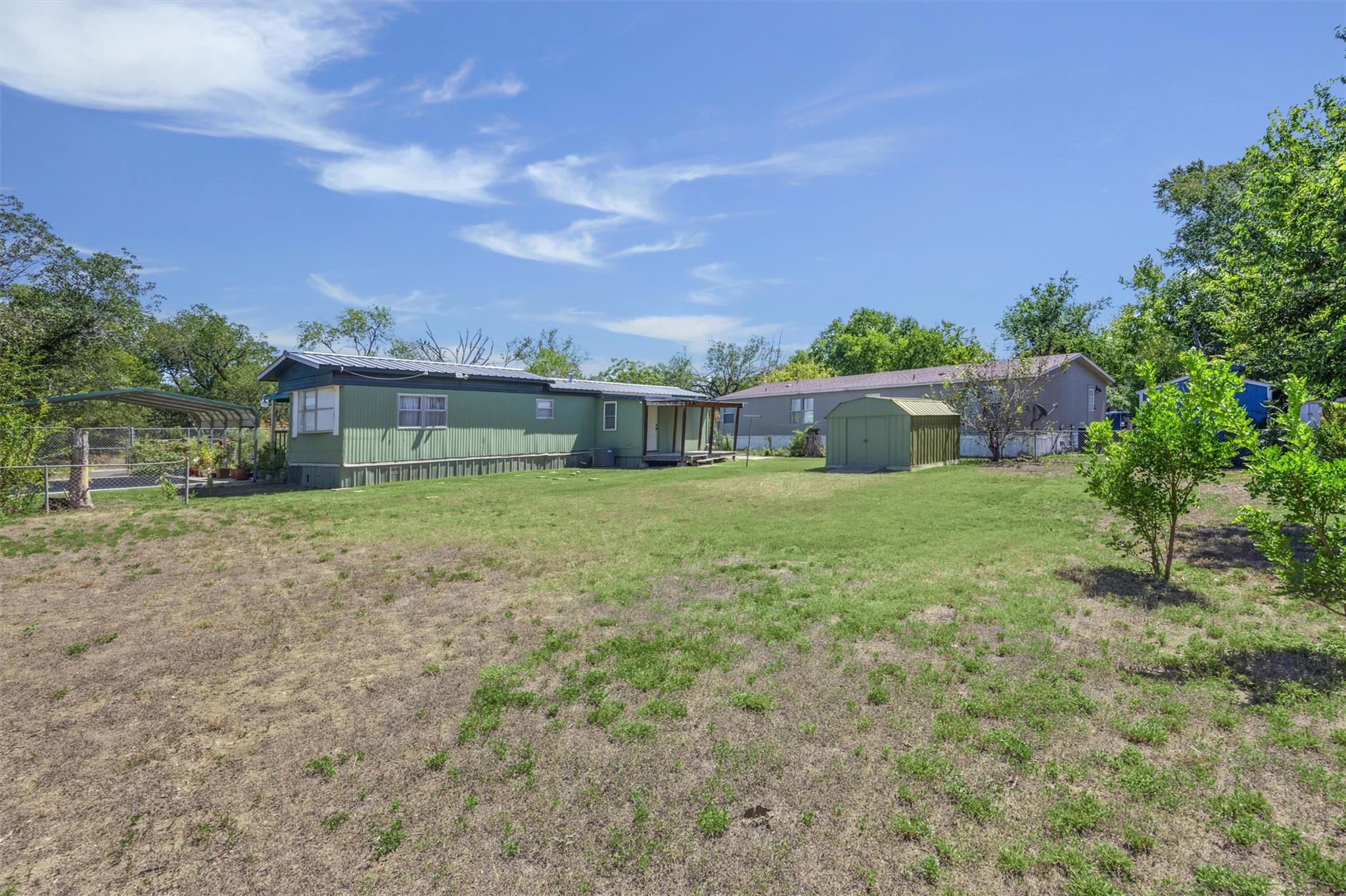 Rear view of property featuring a storage unit an