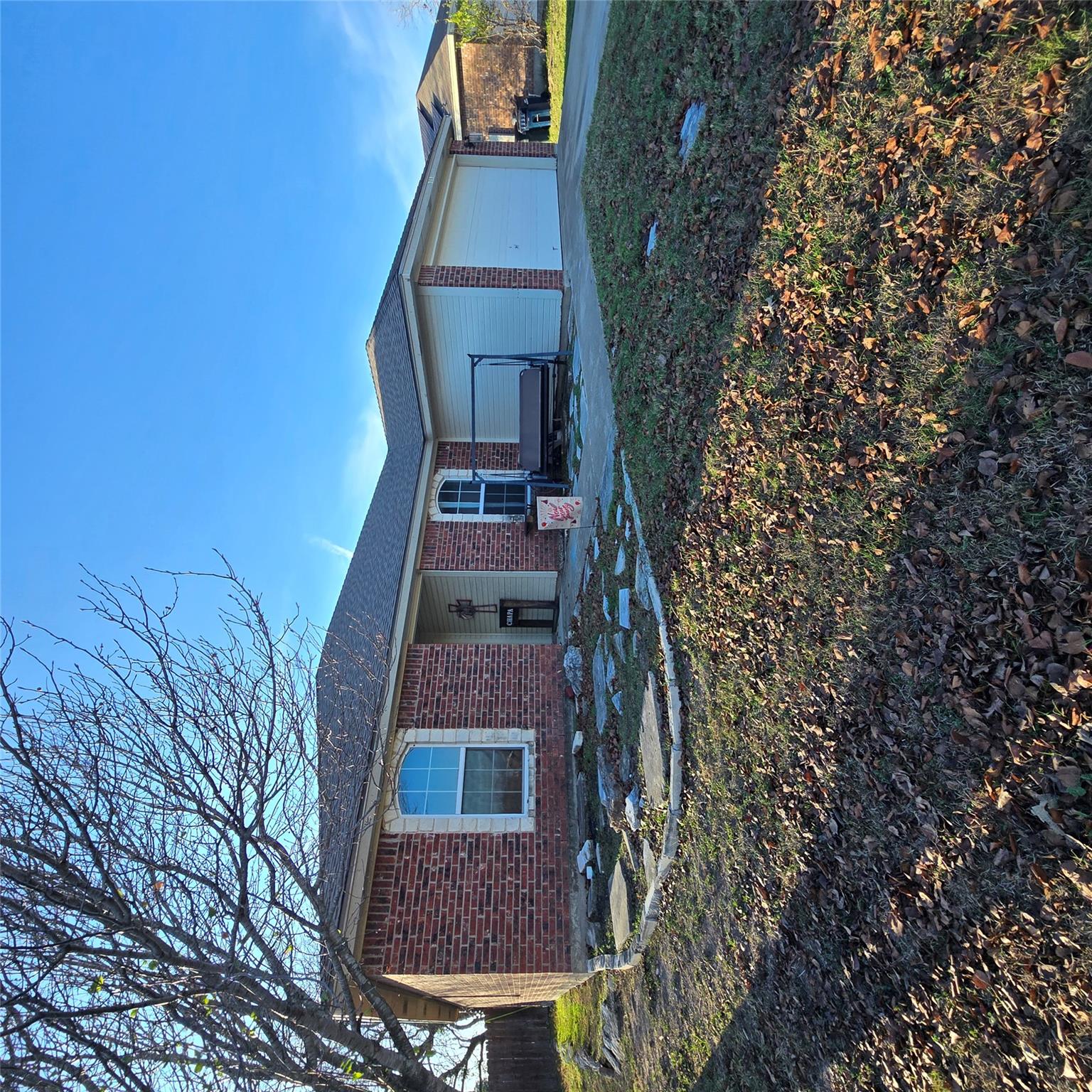 Single story home featuring brick siding, a patio