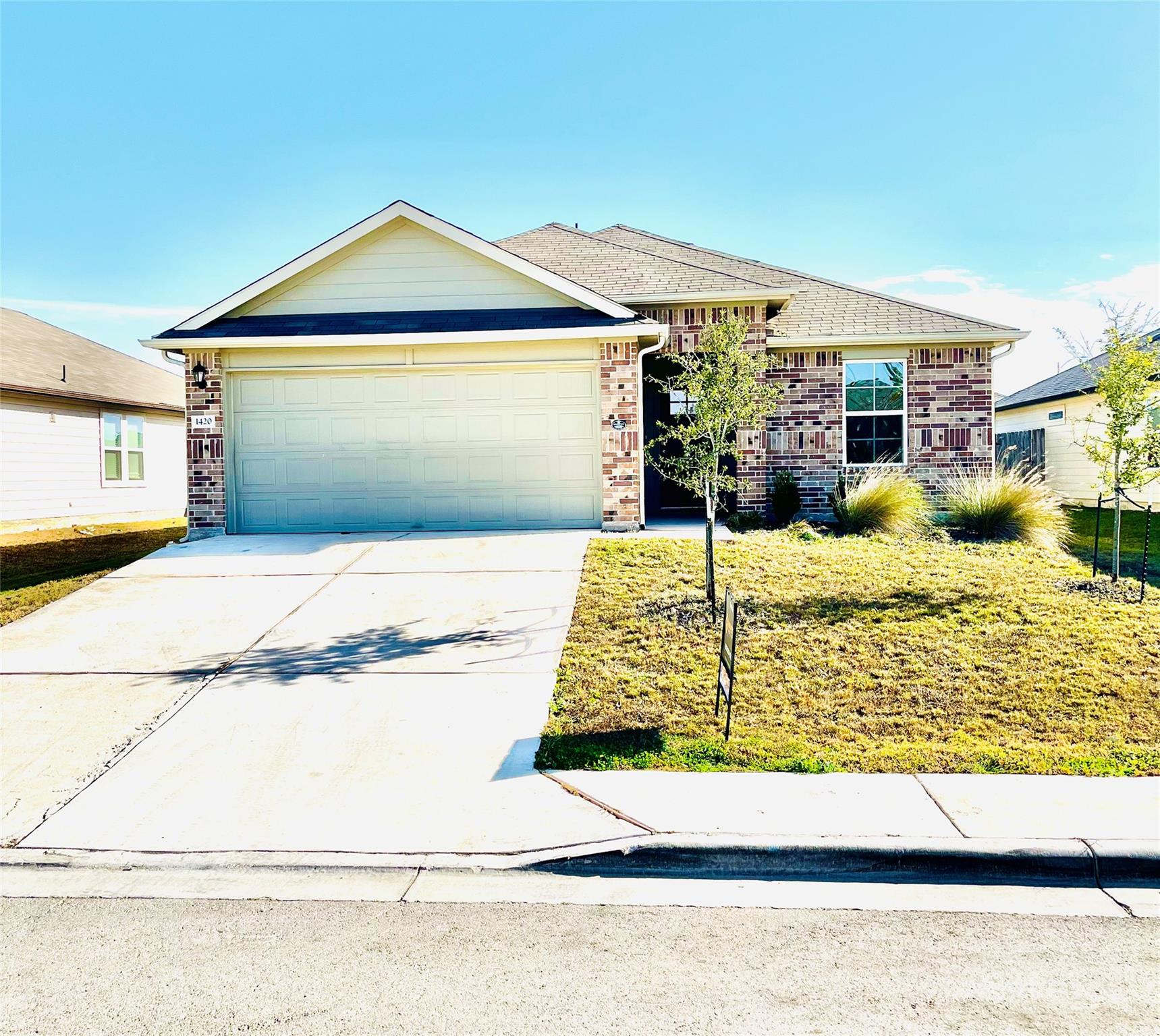 Single story home with brick siding, driveway, a 