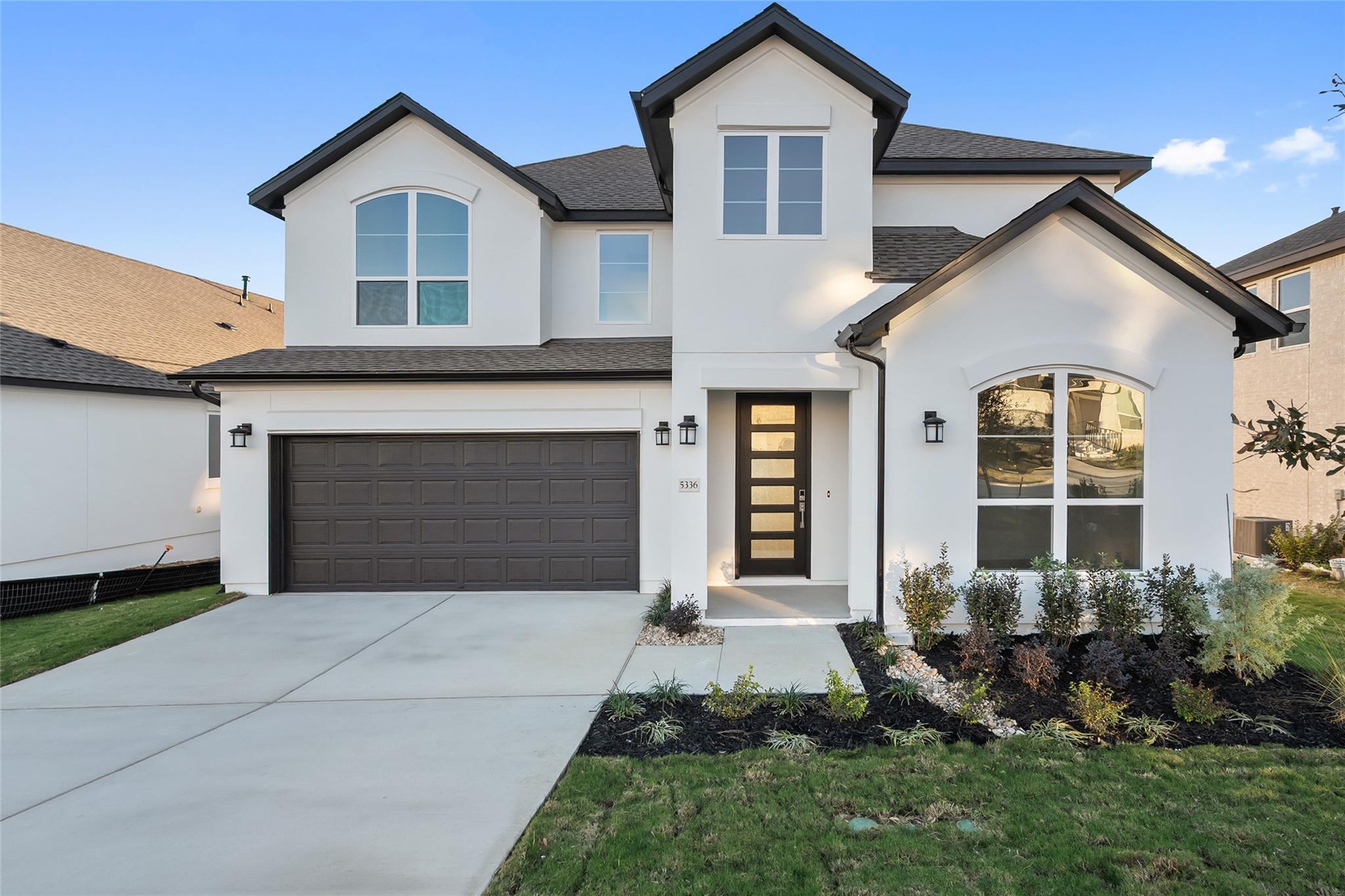 View of front of home with stucco siding, a garag