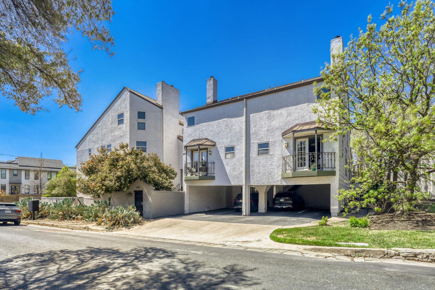 View of front of house featuring a carport, a bal