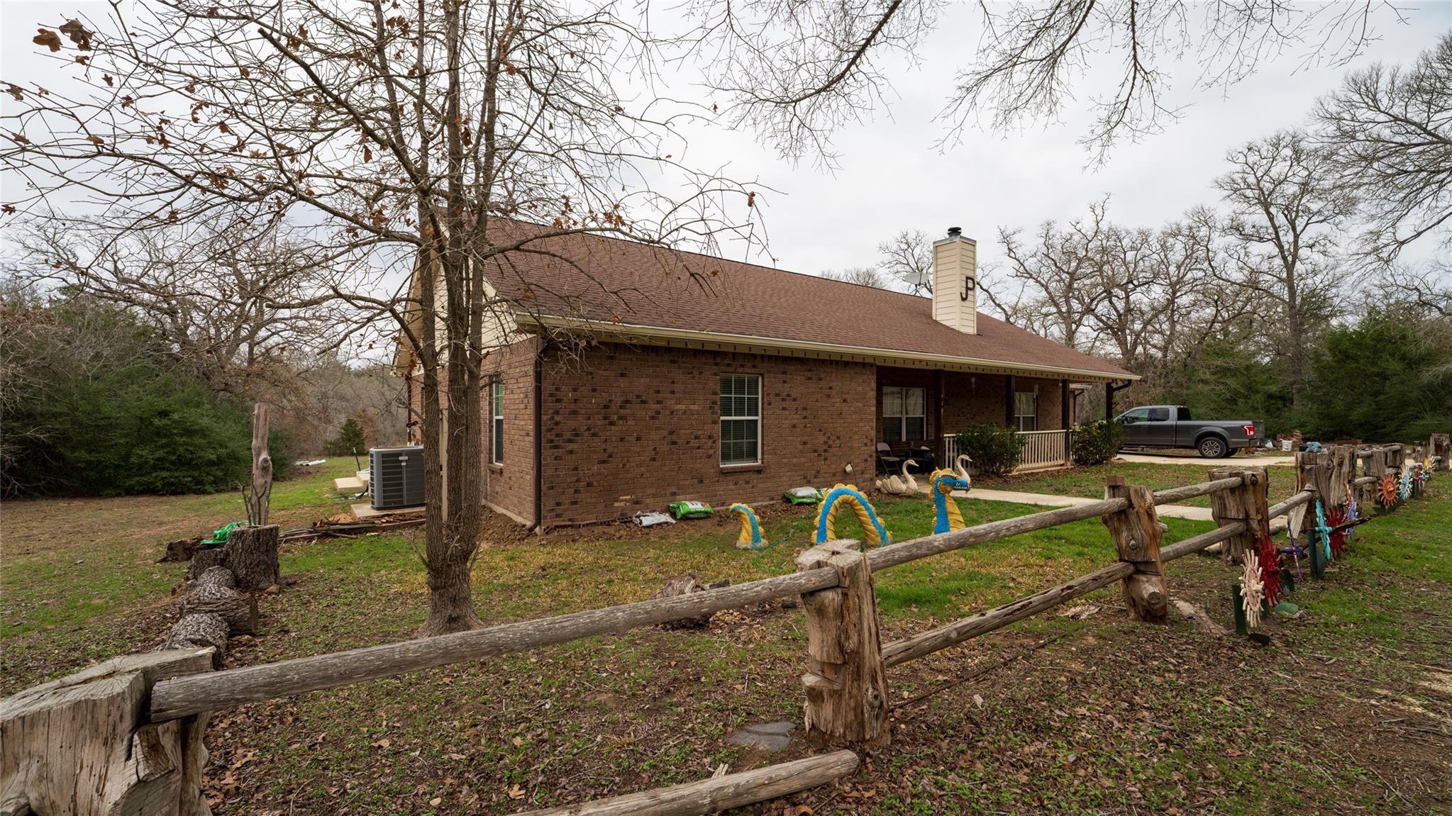 Rear view of property featuring a chimney and bri