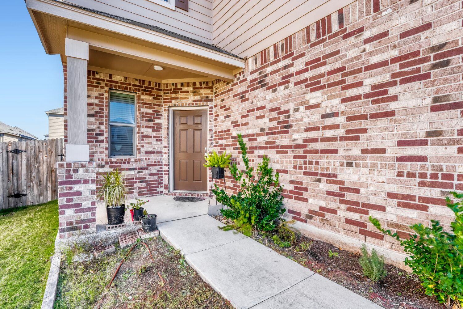 View of exterior entry with brick siding