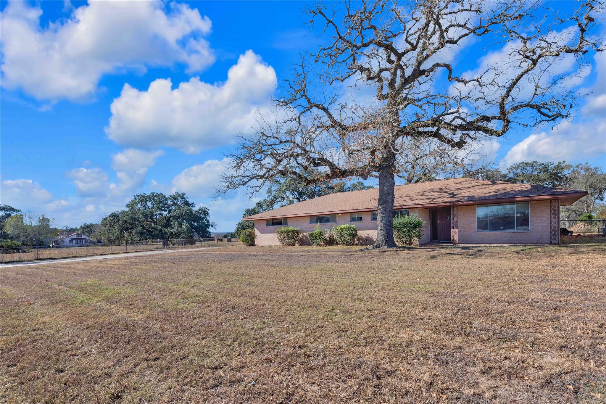 Ranch-style house featuring a front lawn and bric