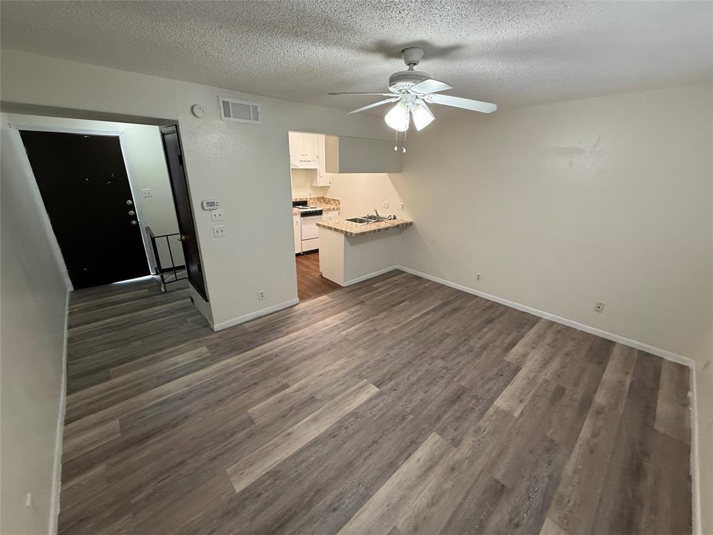 Unfurnished living room with dark wood-style floo