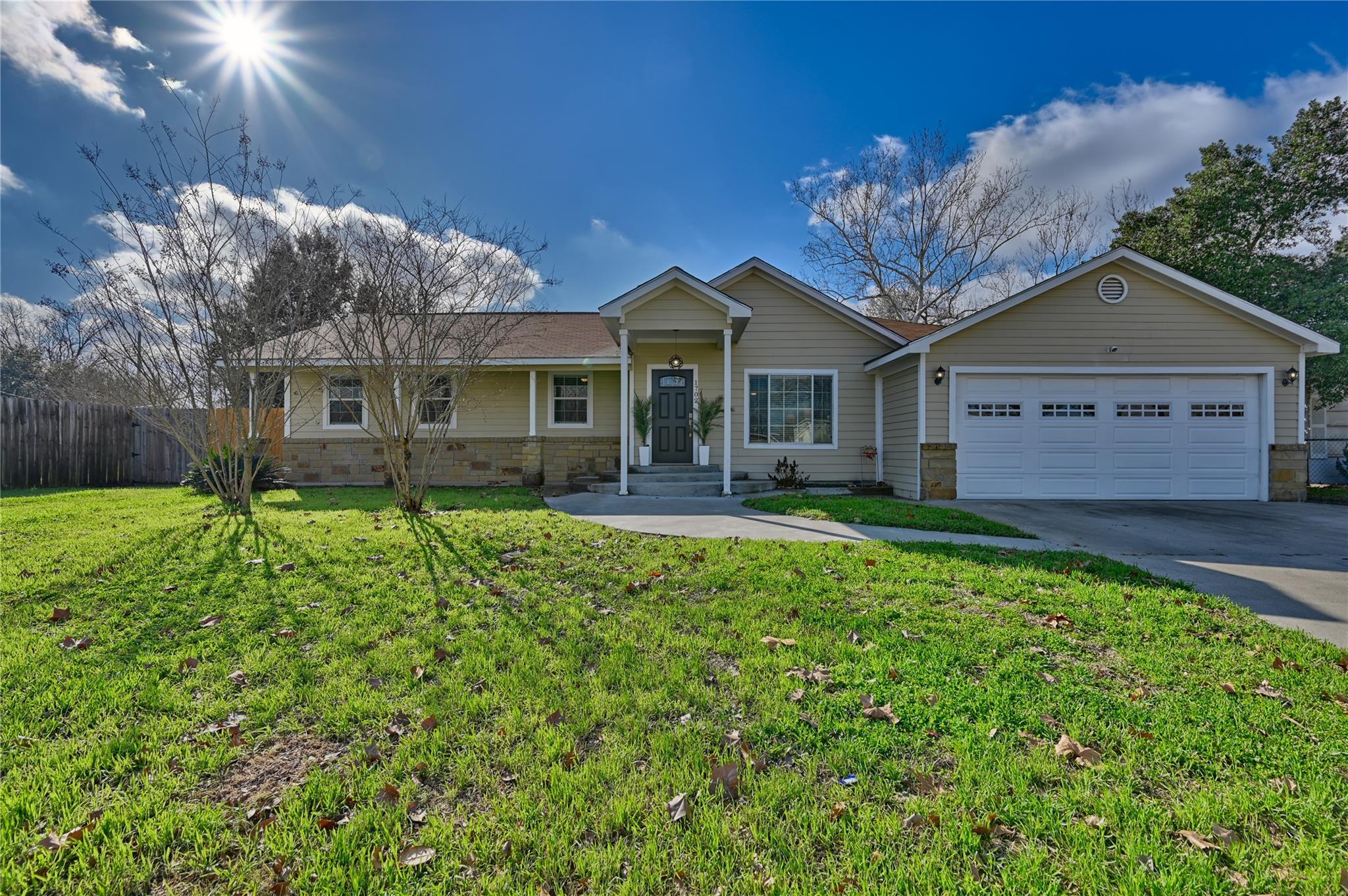 Ranch-style house featuring driveway, stone sidin