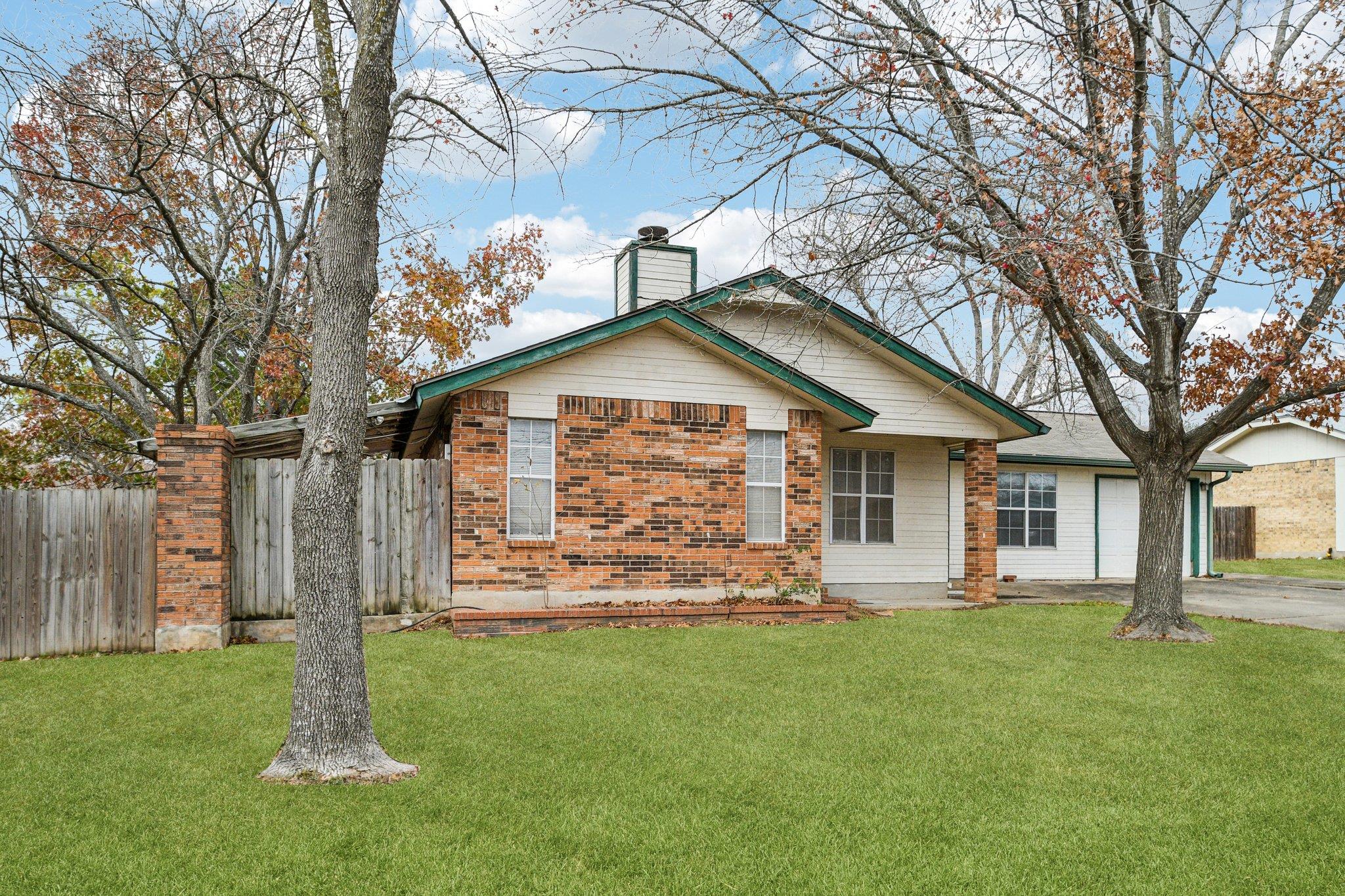Ranch-style house featuring a chimney, brick sidi
