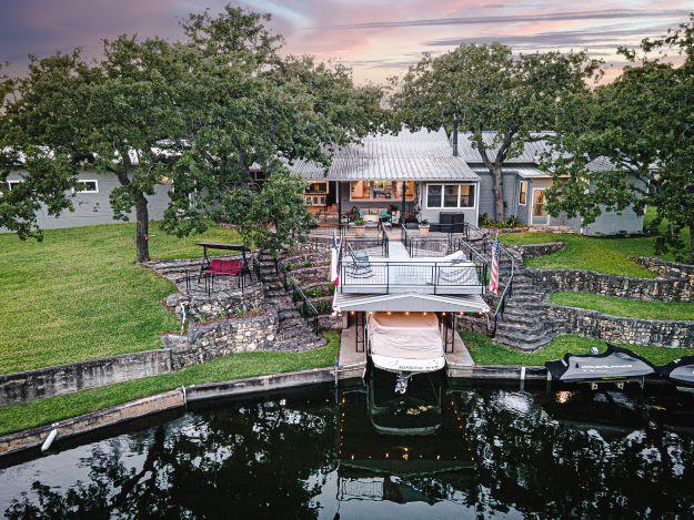 Dock area featuring a patio area, a lawn, and a w