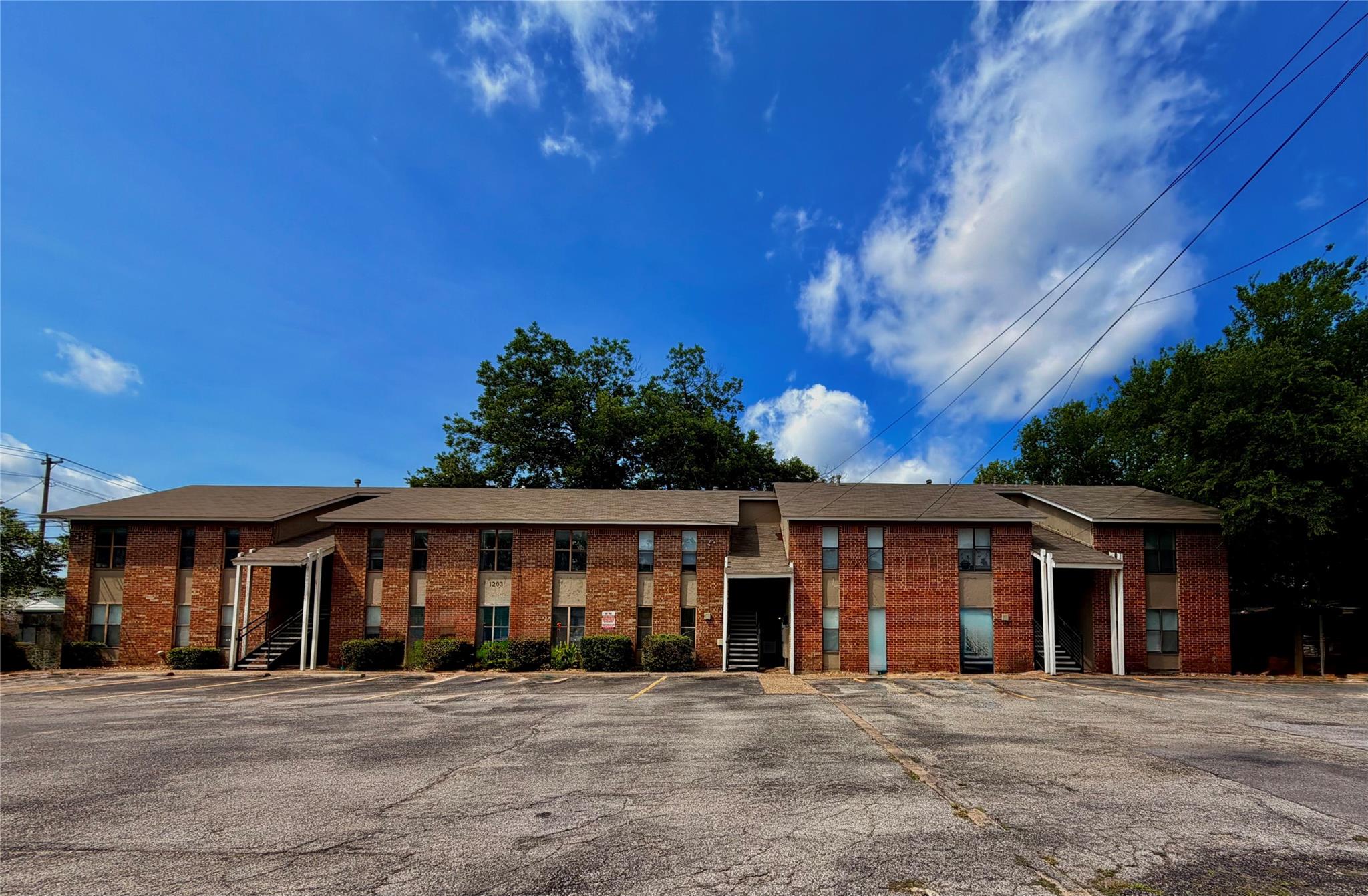 Brick facade and a spacious parking lot frame thi