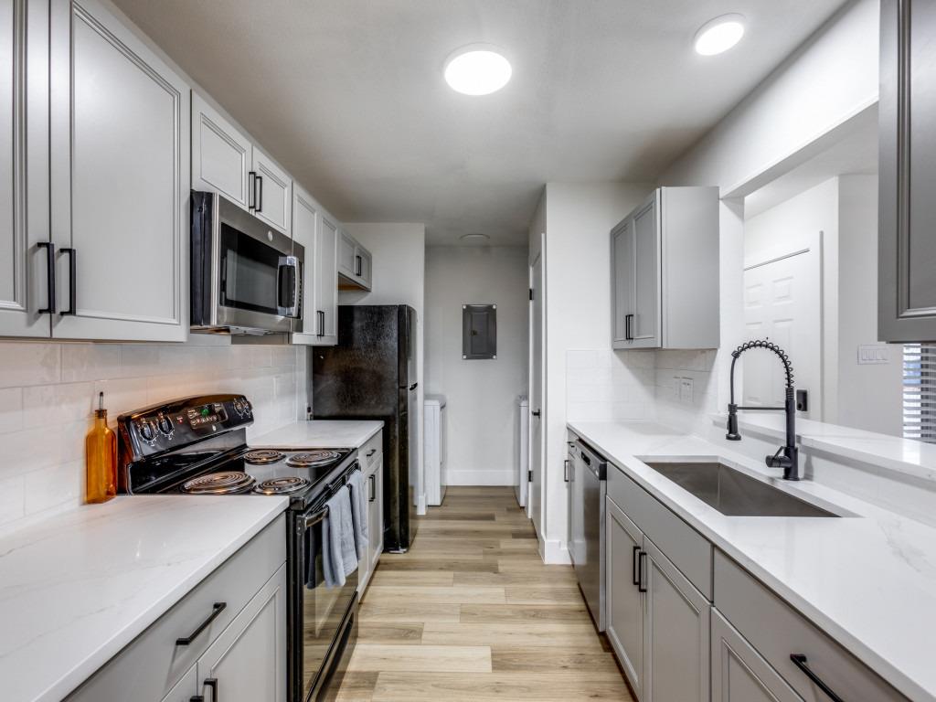 Kitchen featuring gray cabinetry, appliances with