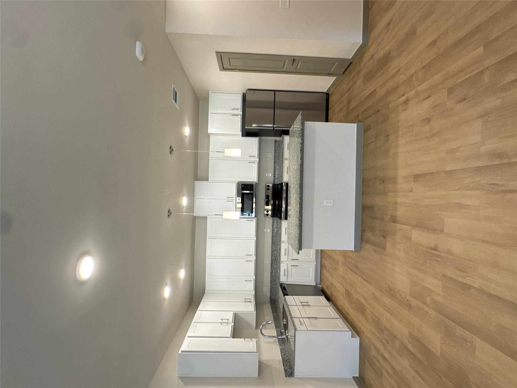 Kitchen featuring hanging light fixtures, white c