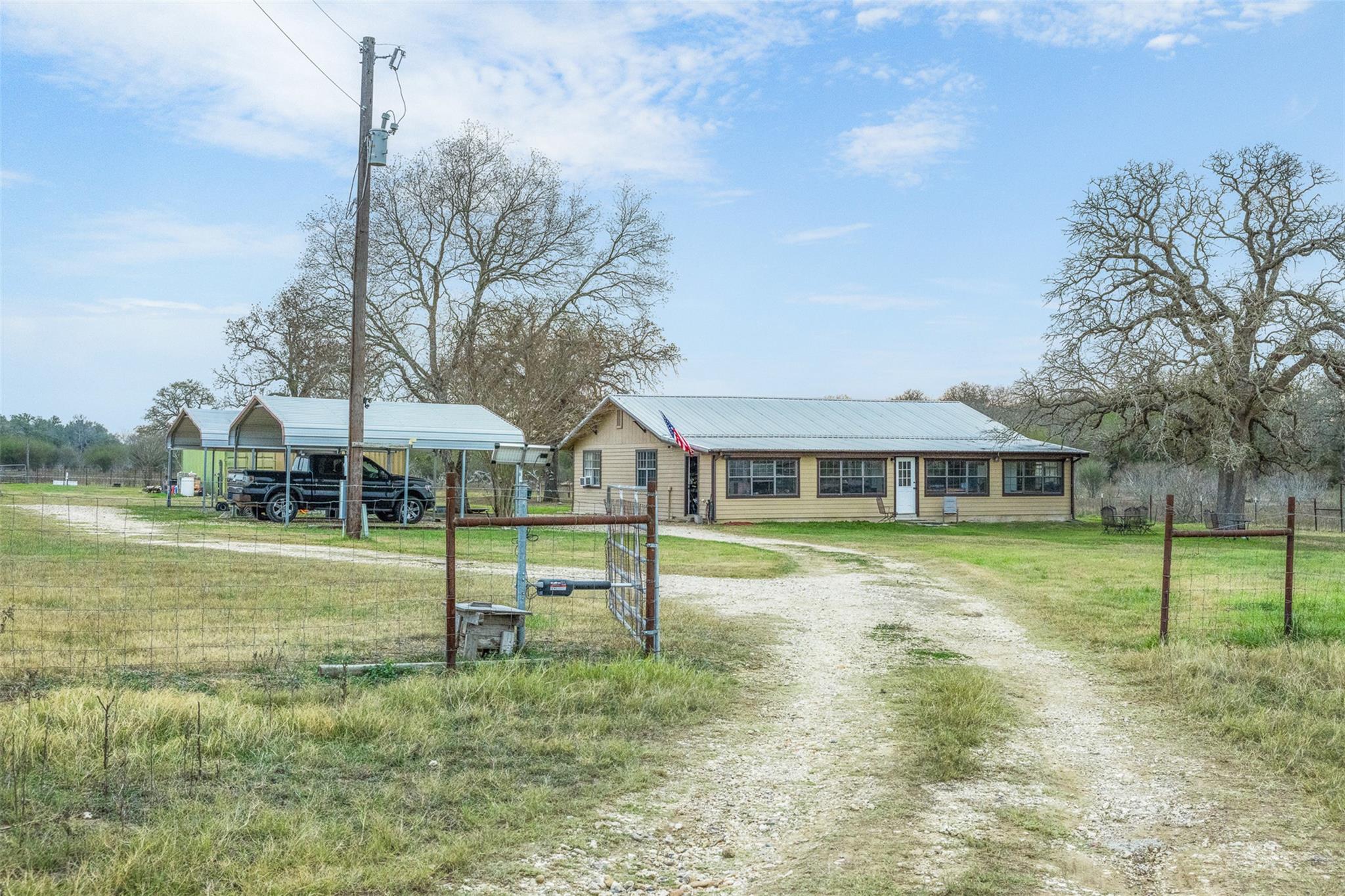 Ranch-style home with a detached carport and driv