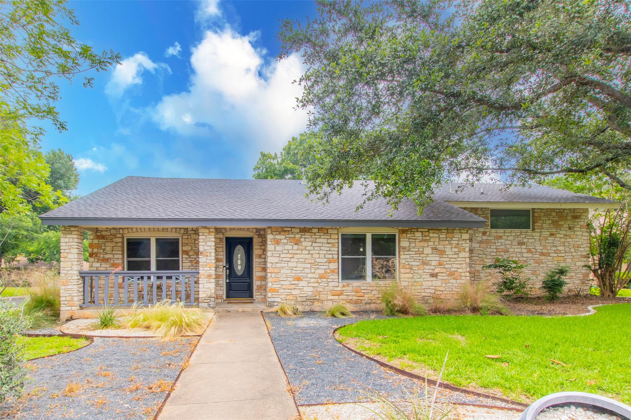 A classic stone facade home awaits, featuring a c