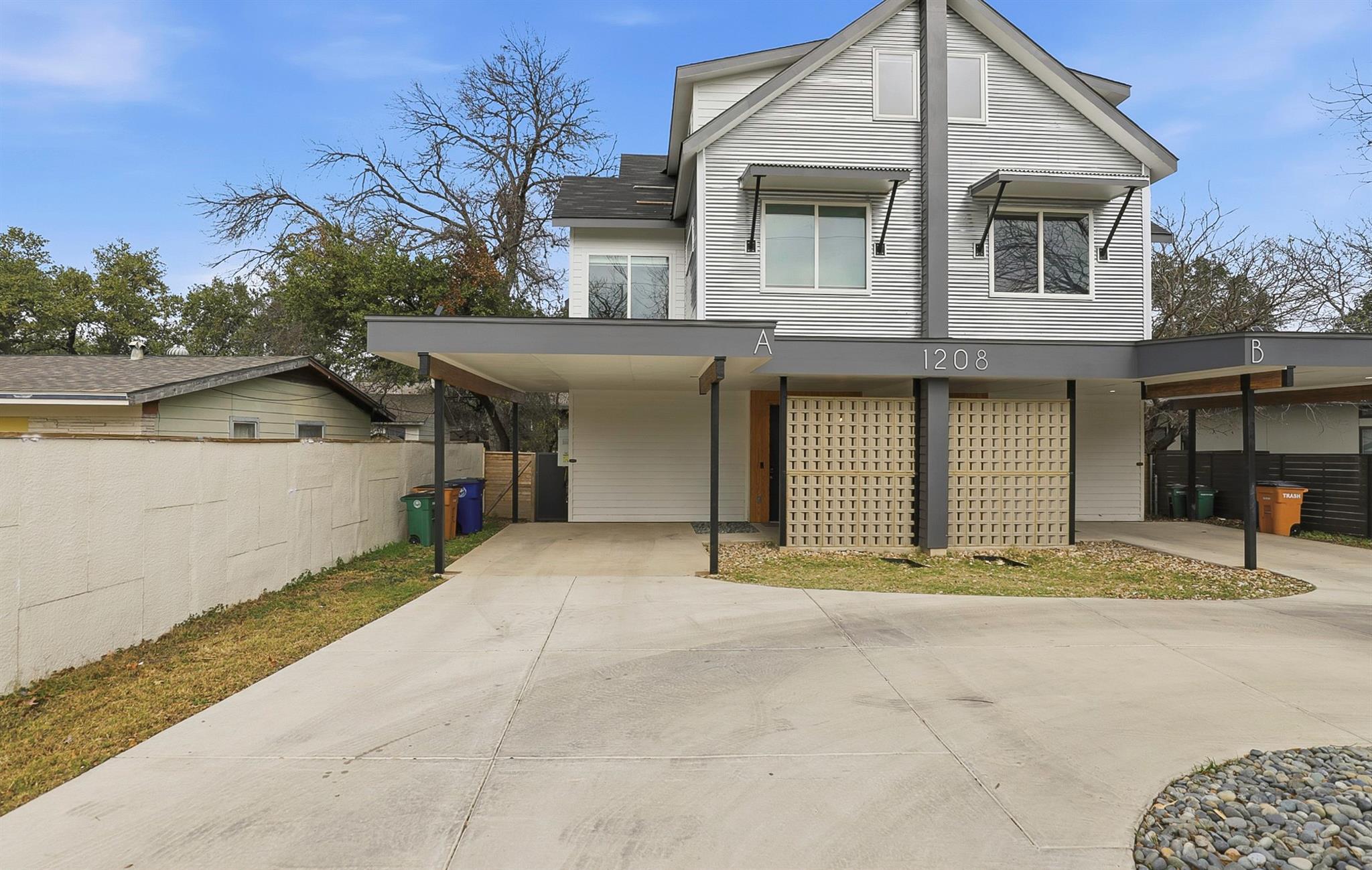 View of front of home with driveway and a shingle