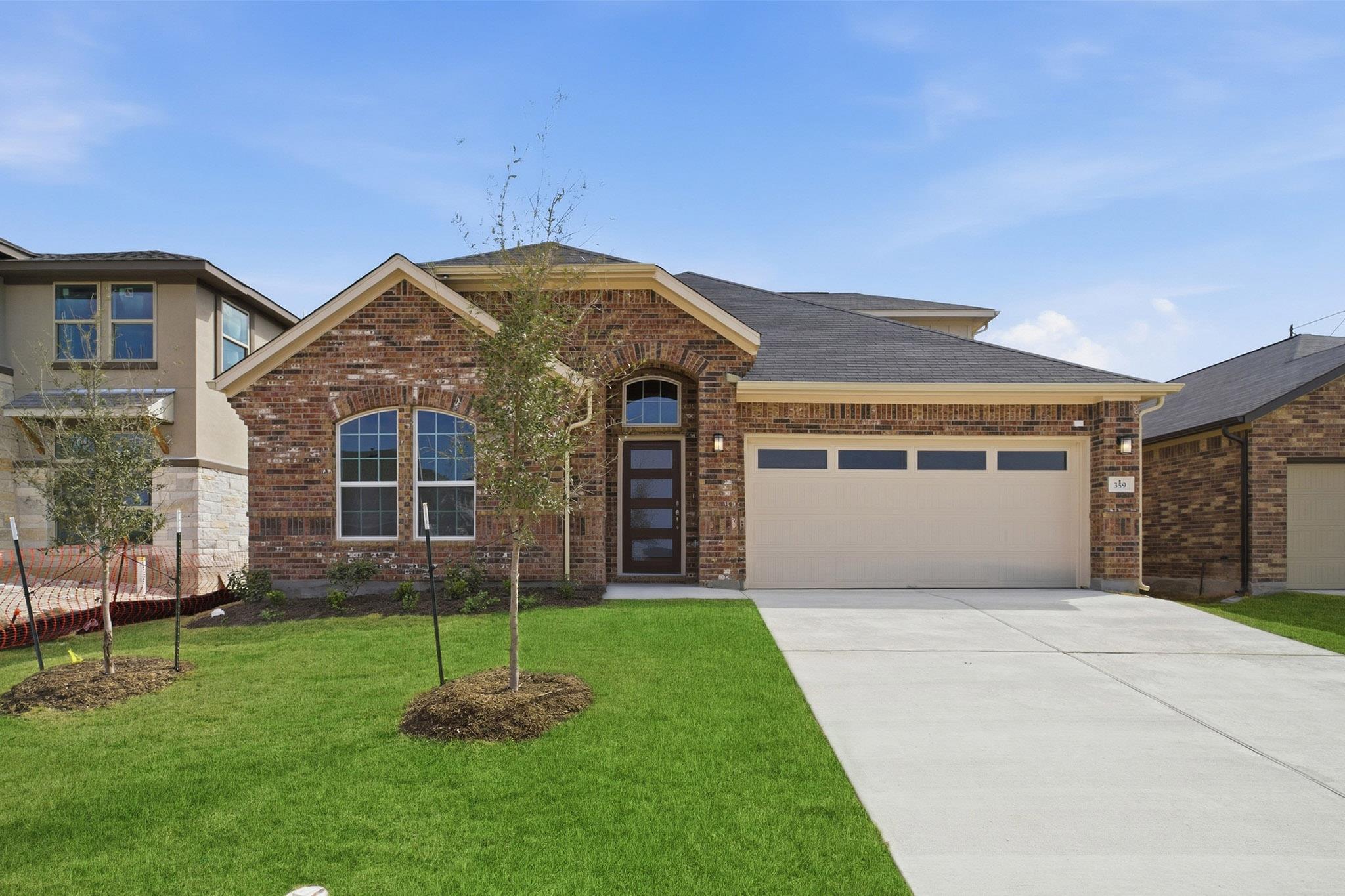 View of front of house with brick siding, an atta