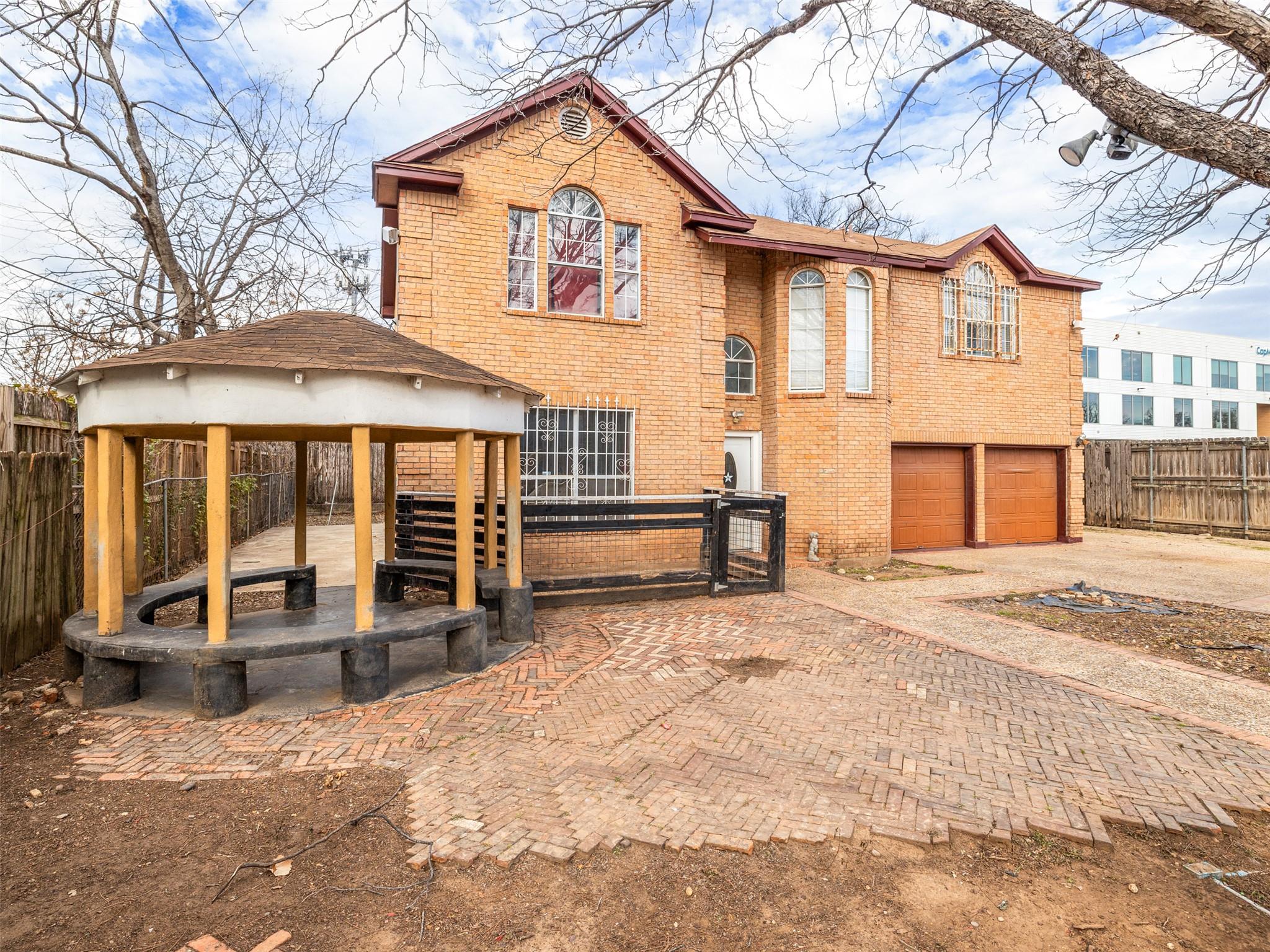 Back of house with a garage, decorative driveway,