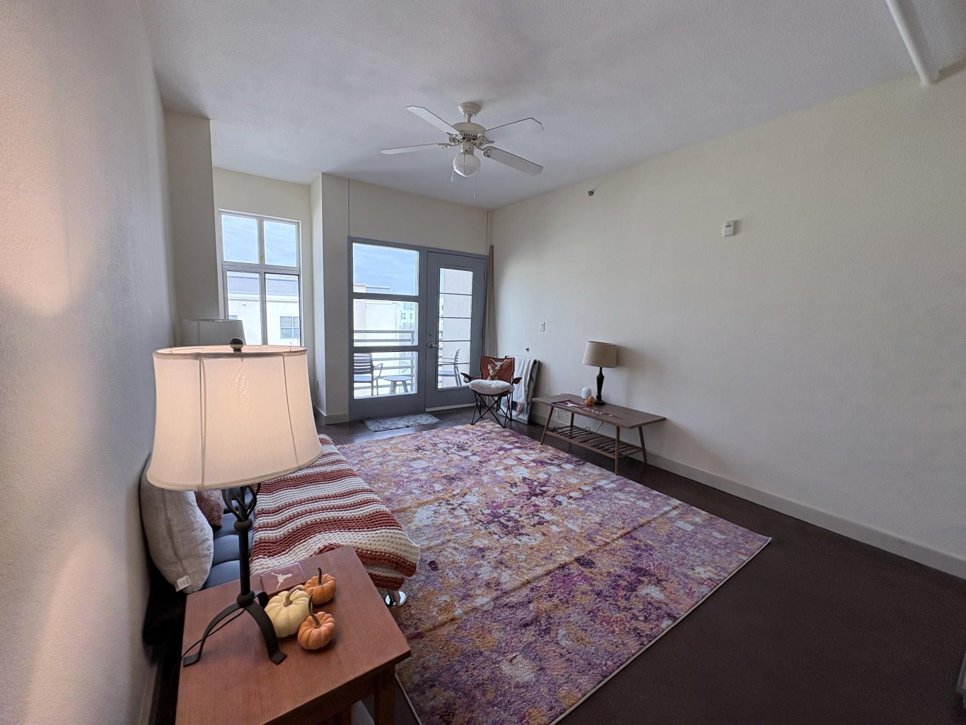Living area featuring baseboards and a ceiling fan