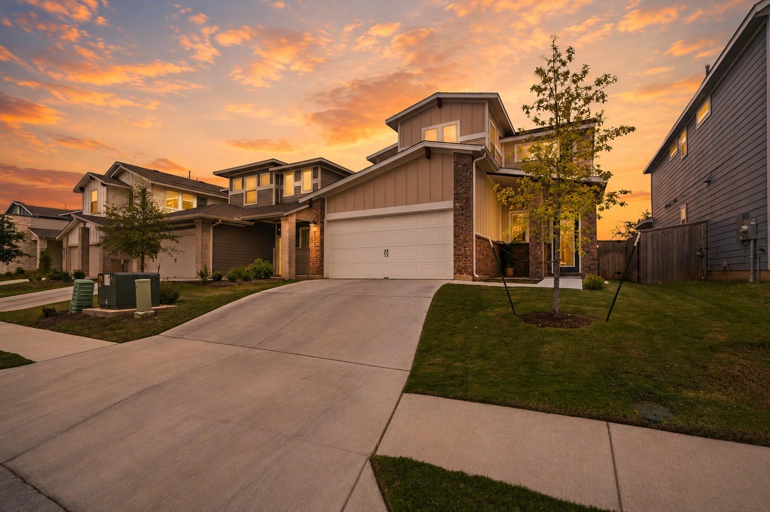 A well-maintained lawn and concrete driveway lead