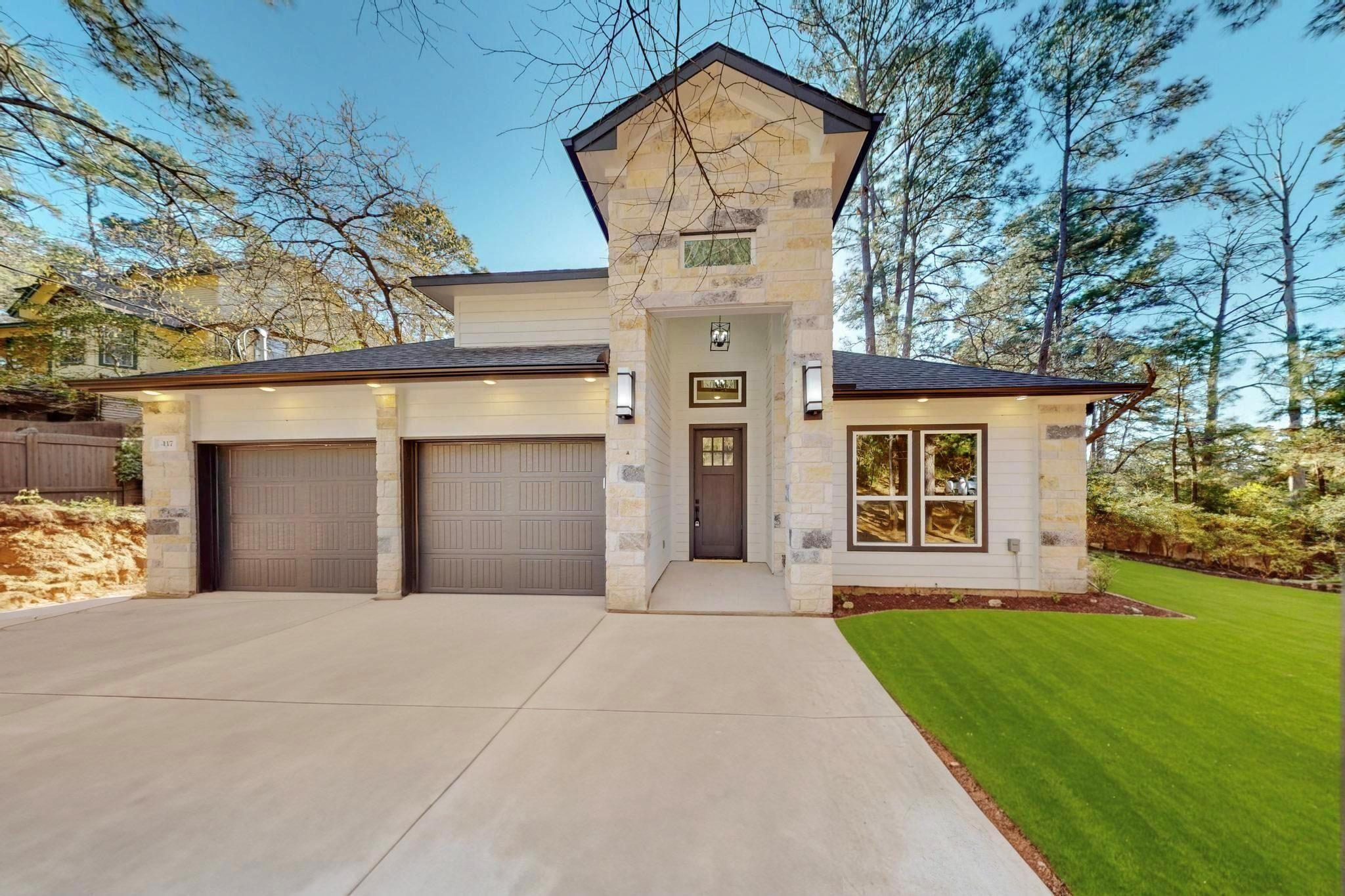 View of front of house with a front yard, stone s