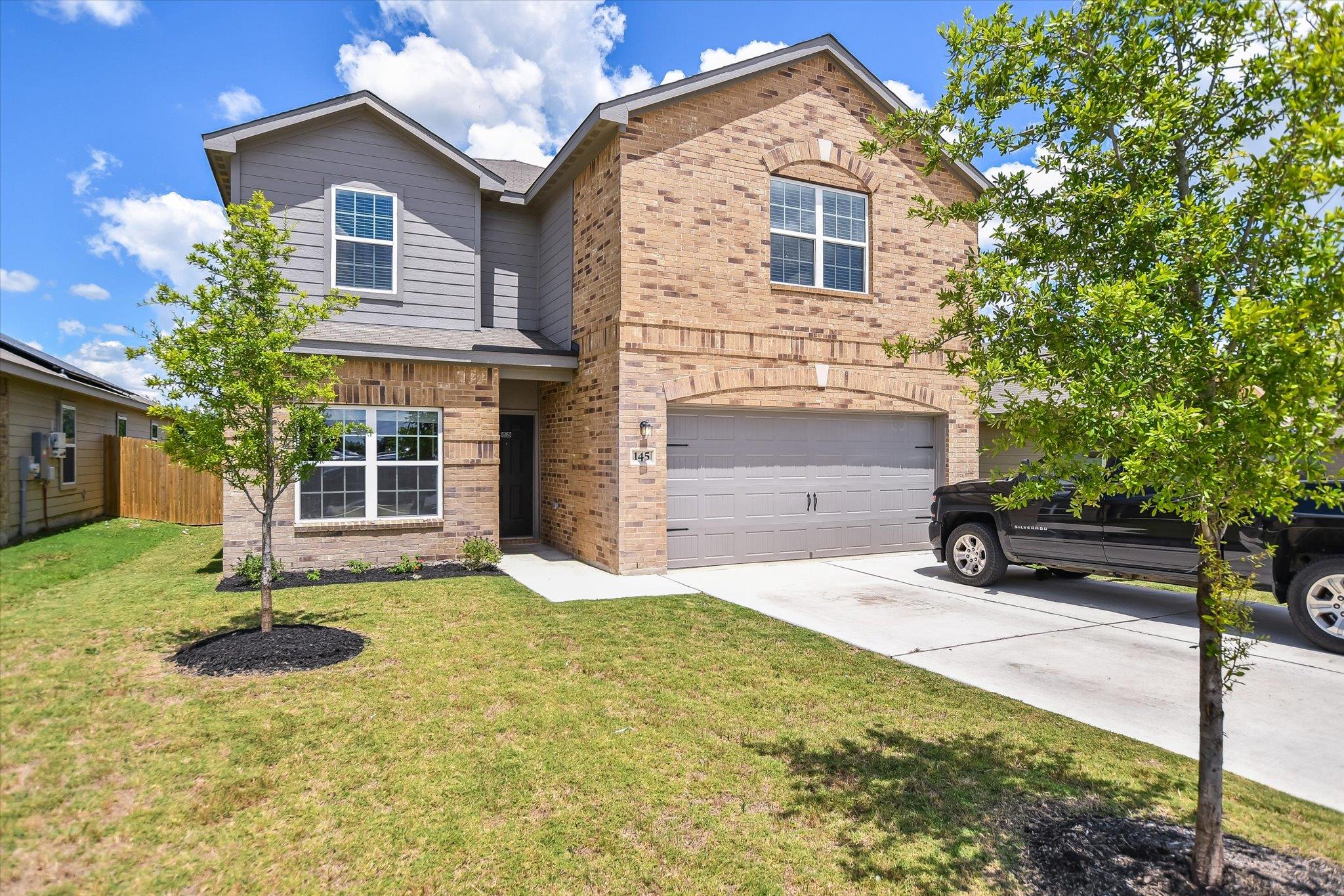 Traditional home featuring brick siding, a garage