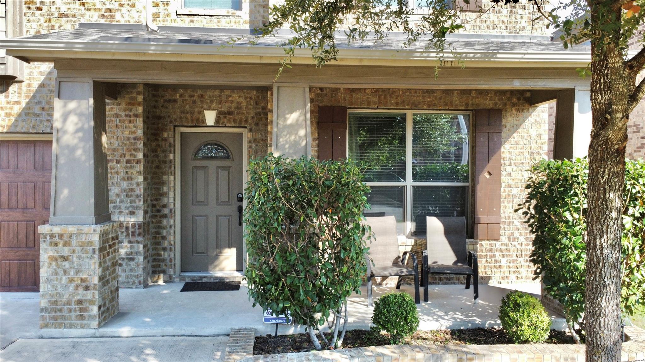 Property entrance featuring covered porch and bri