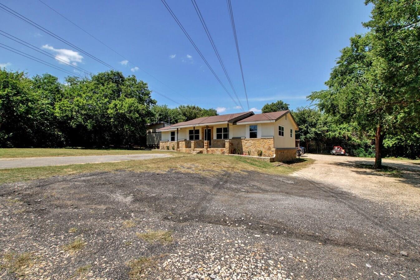 Single story home with stone siding, view of scat
