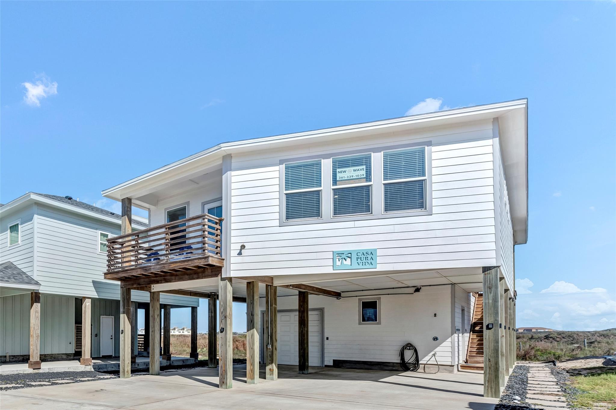Rear view of property with a carport, a balcony, 