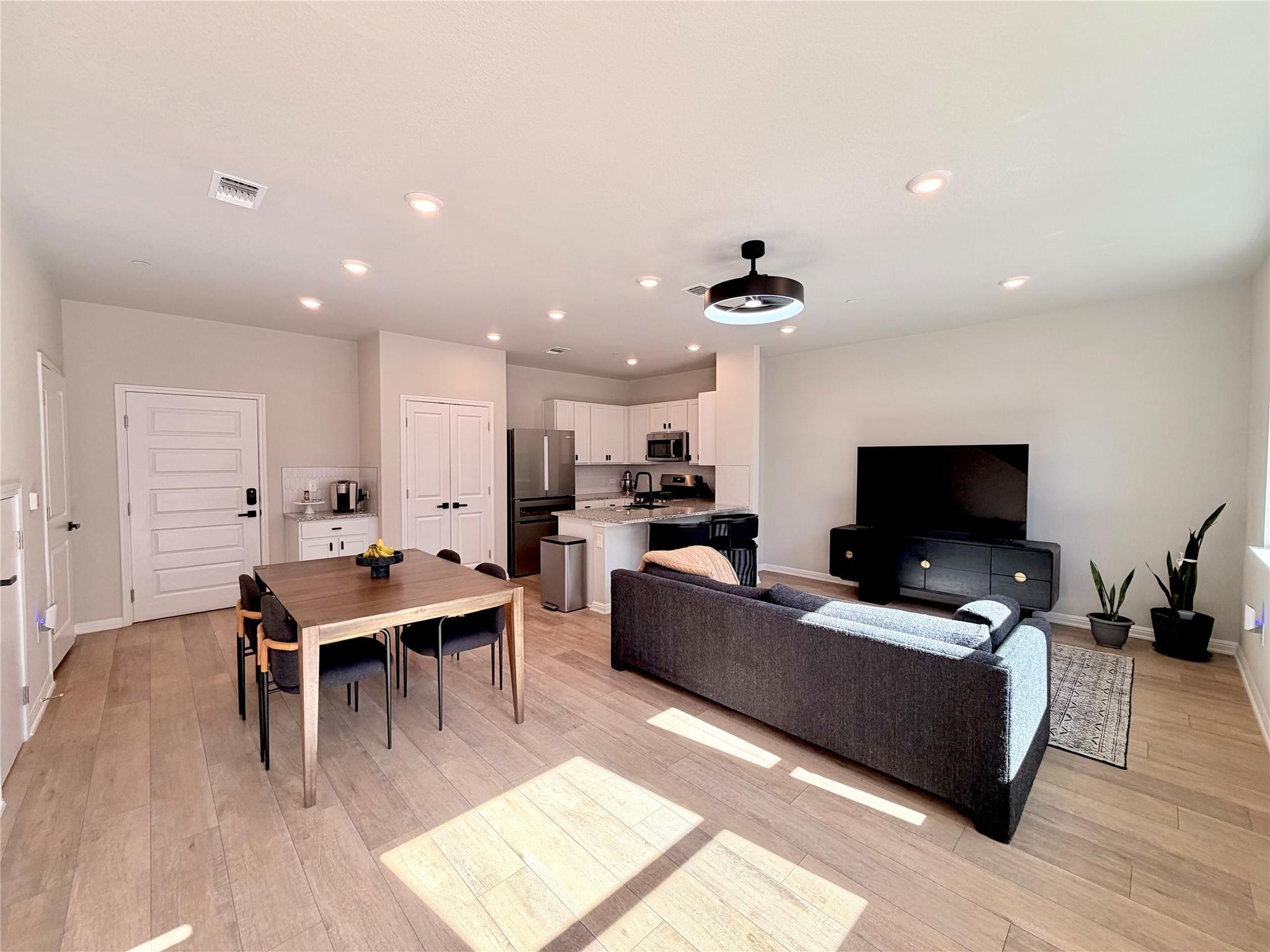 Living area with recessed lighting and light wood