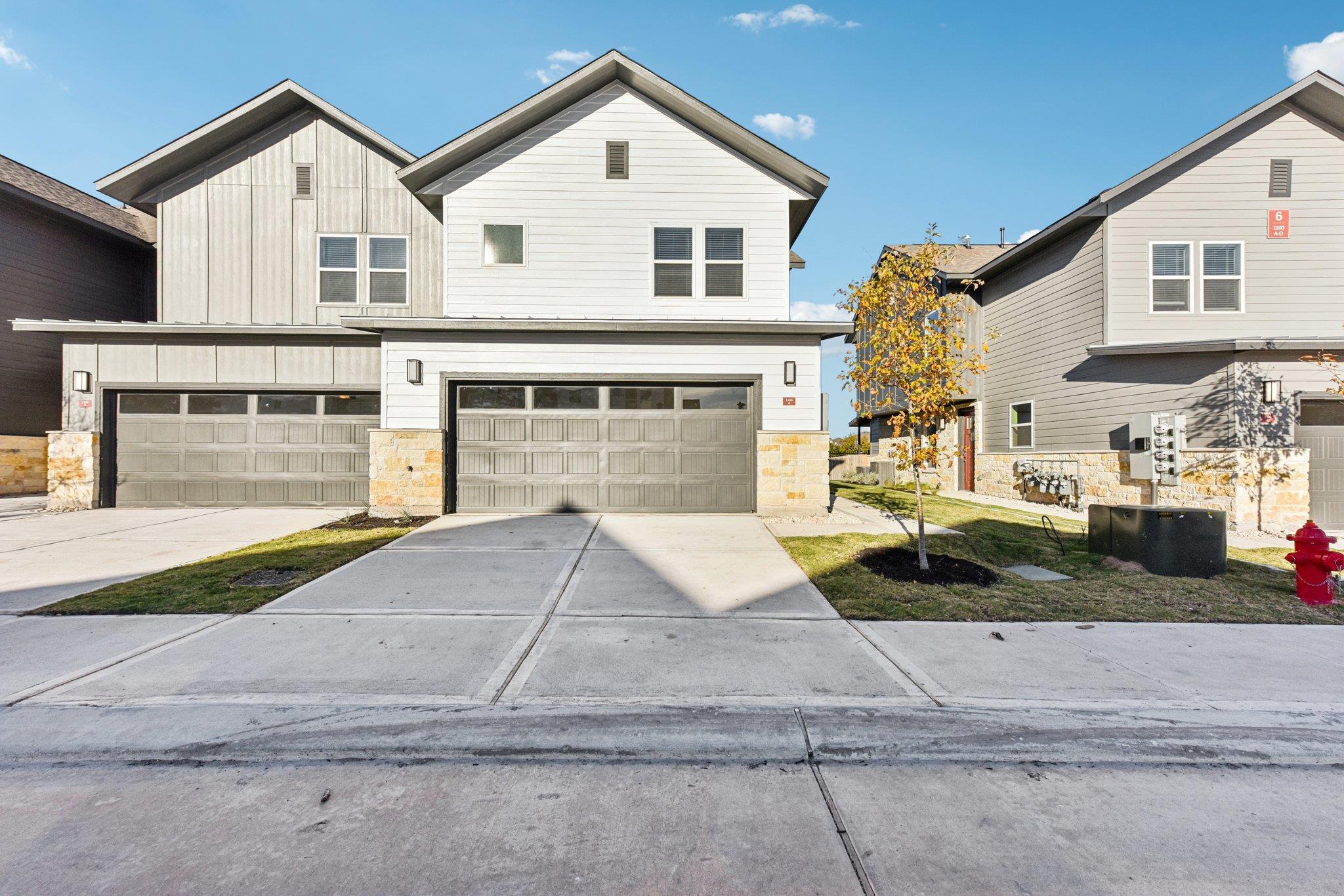 View of front facade featuring stone siding, a ga