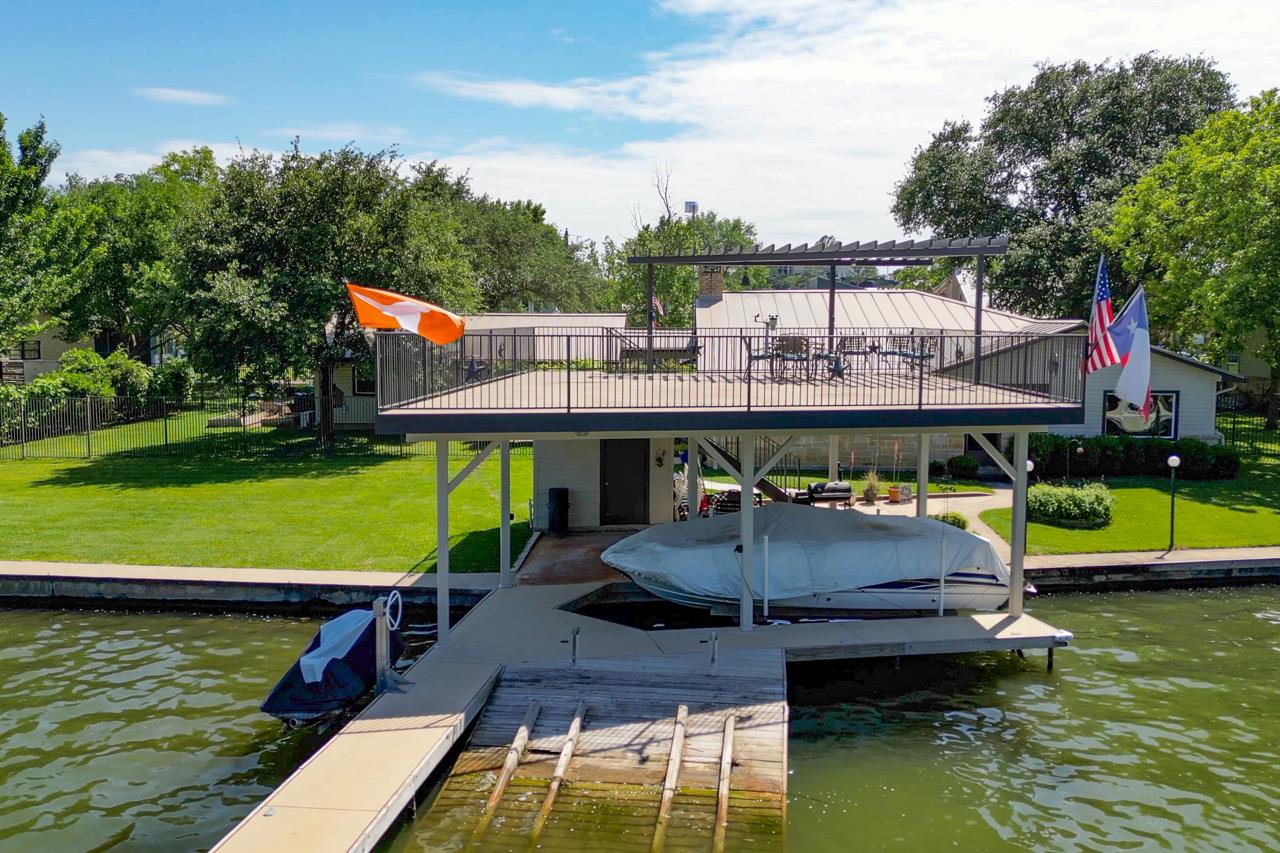 Dock with a water view, a lawn, and boat lift