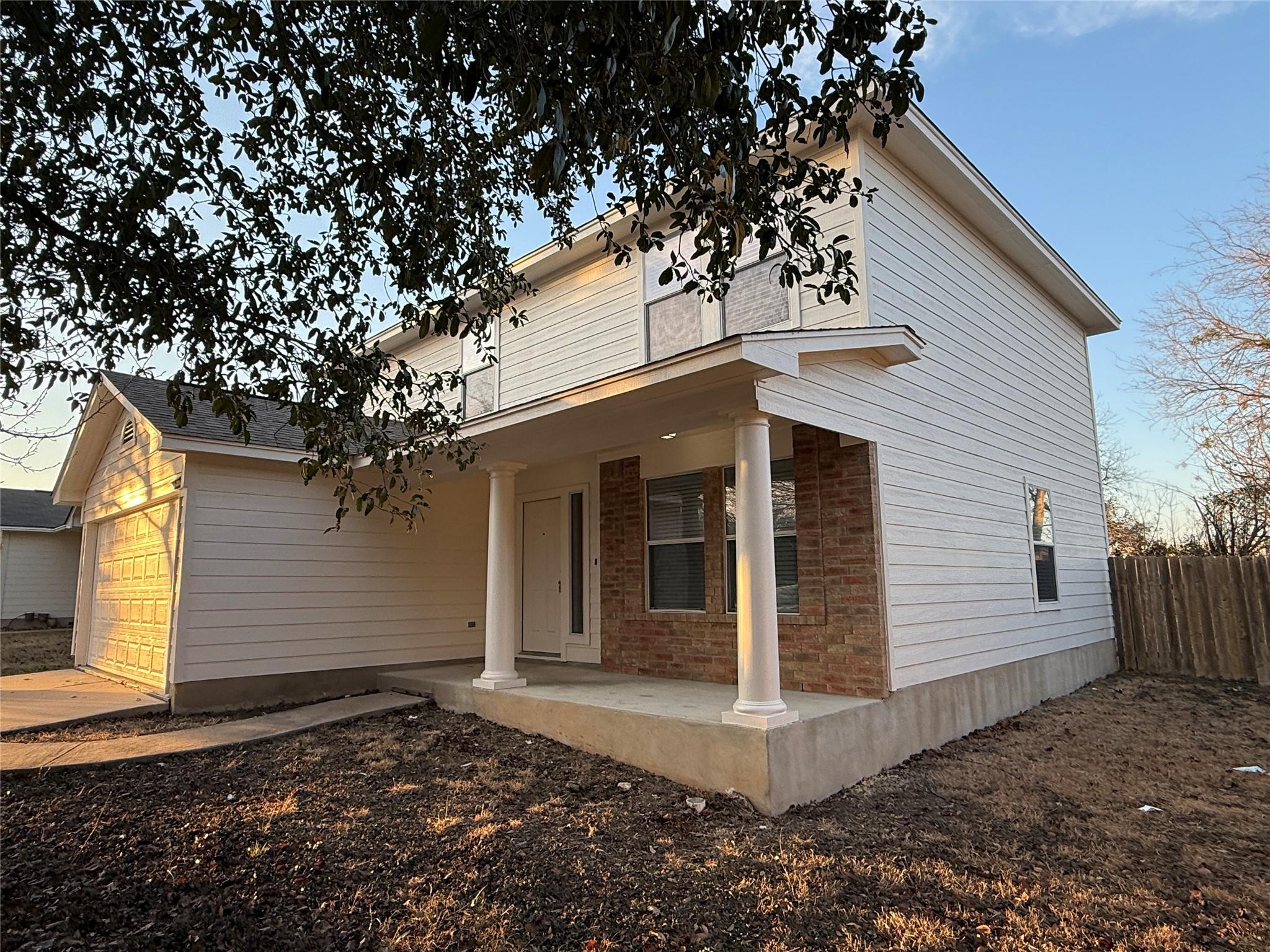 Rear view of house featuring brick siding, a gara