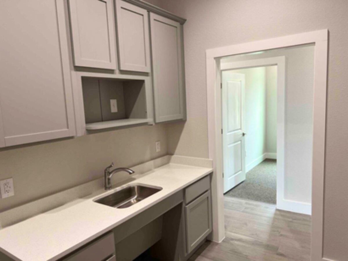 Kitchen featuring gray cabinetry and light wood-s