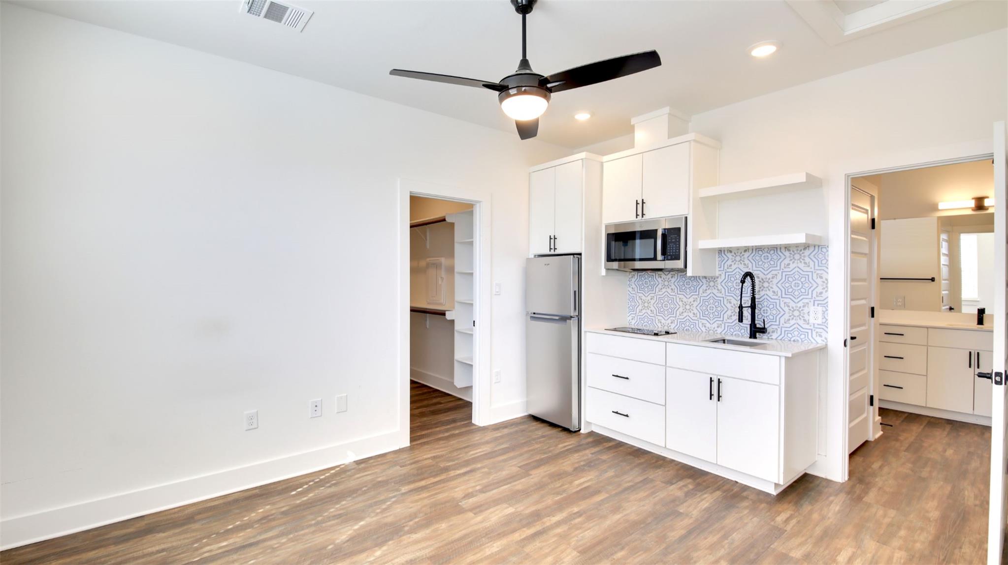 Kitchen with white cabinets, open shelves, stainl