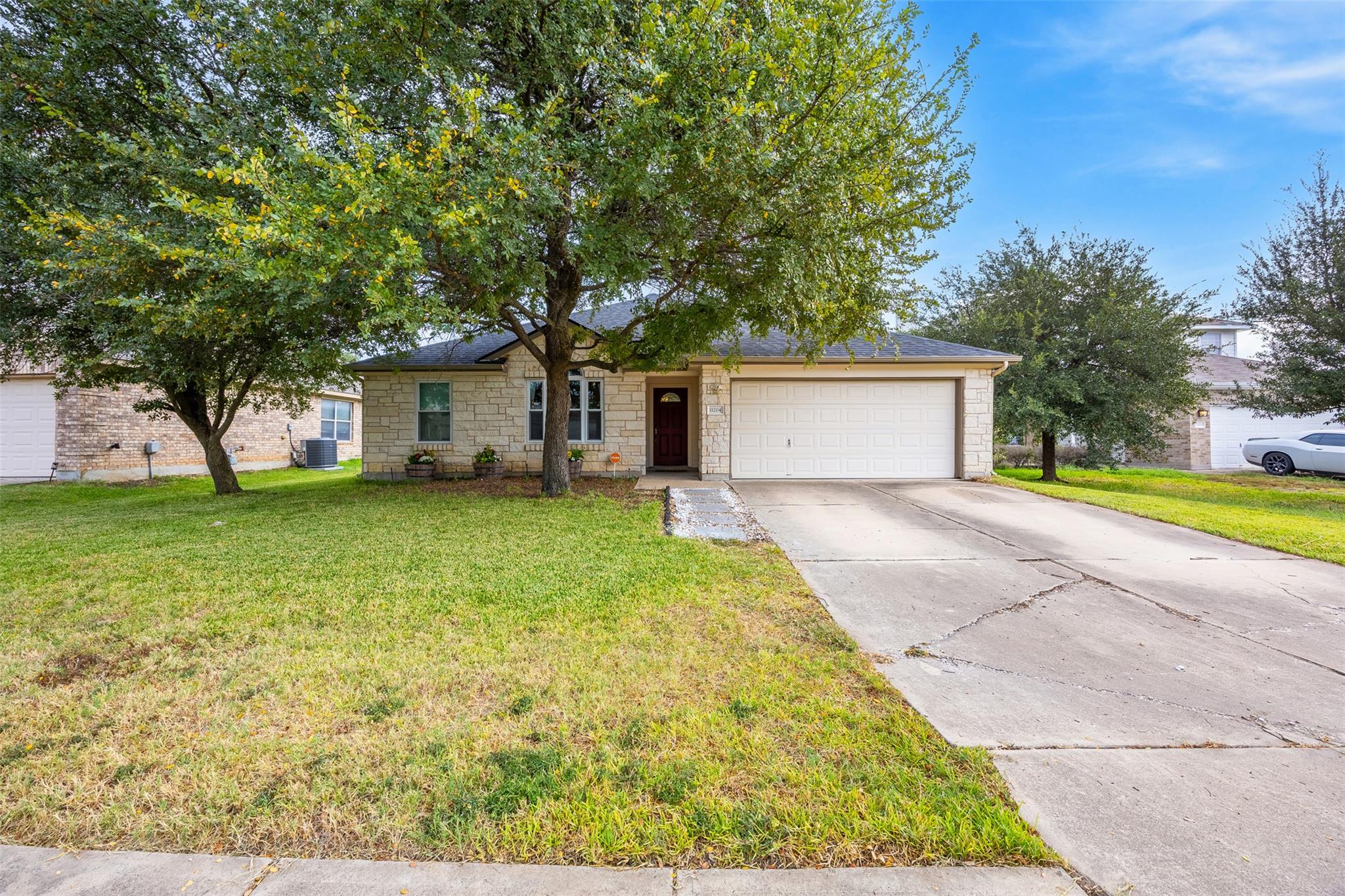 Ranch-style home with driveway, a front lawn, sto