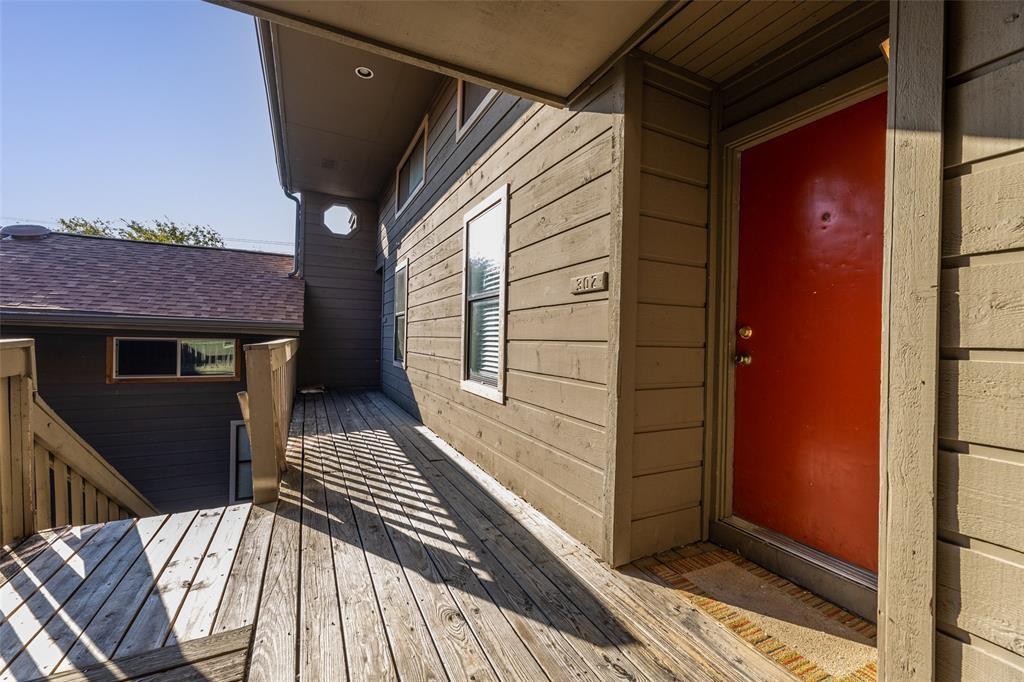 Doorway to property with a deck and a shingled ro
