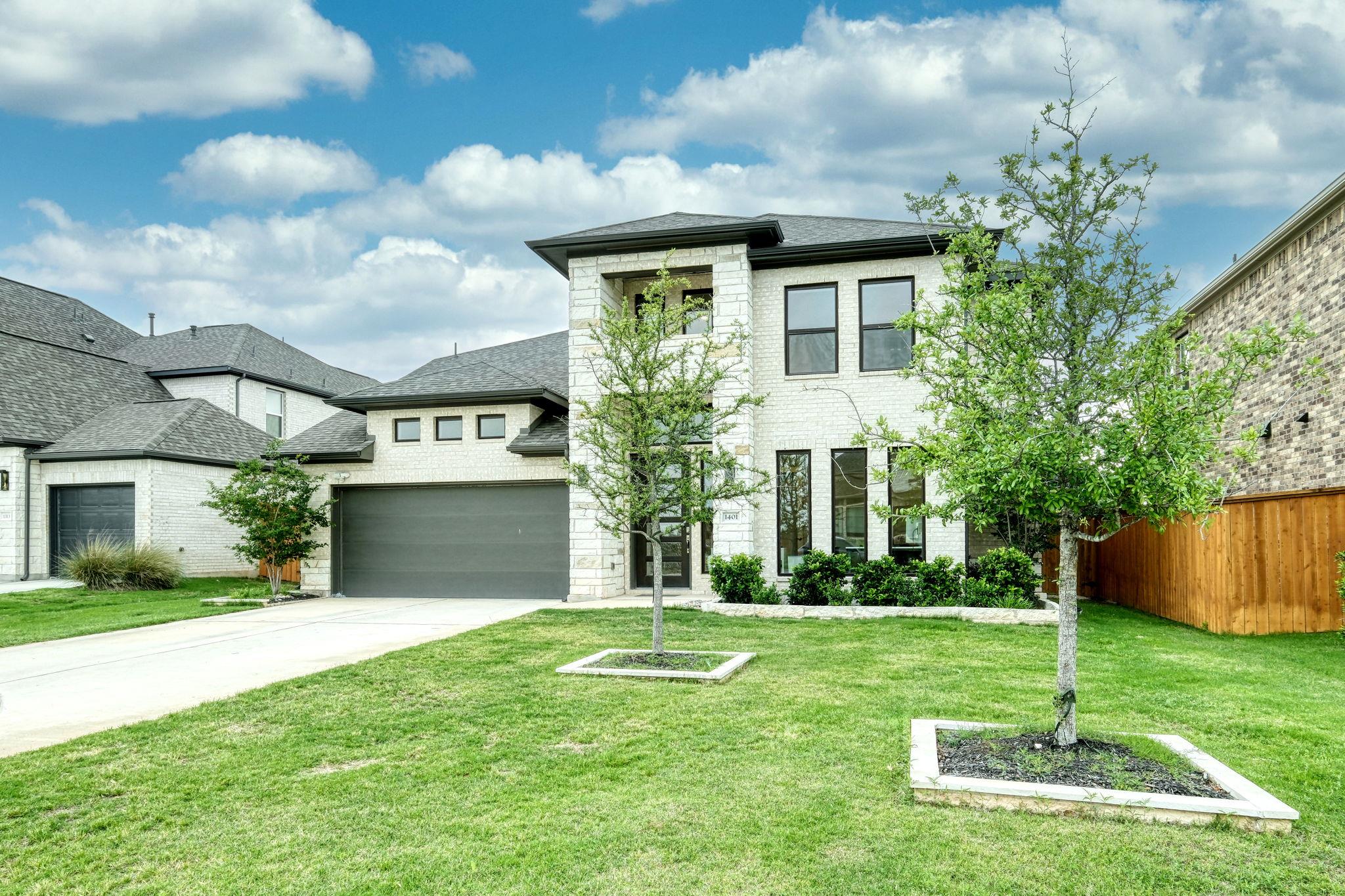 View of front of home with a front yard, driveway