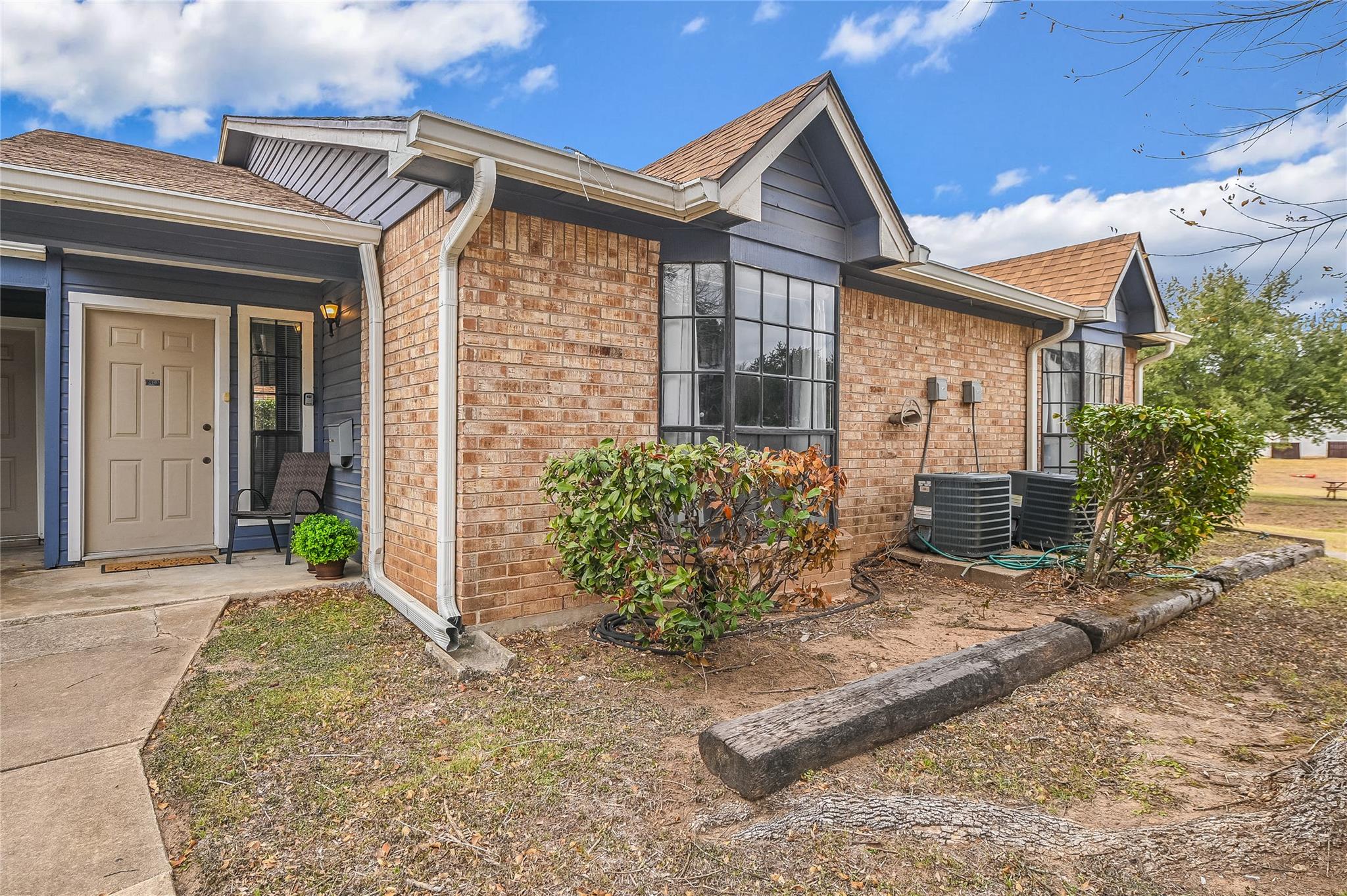 View of side of home with brick siding and a shin