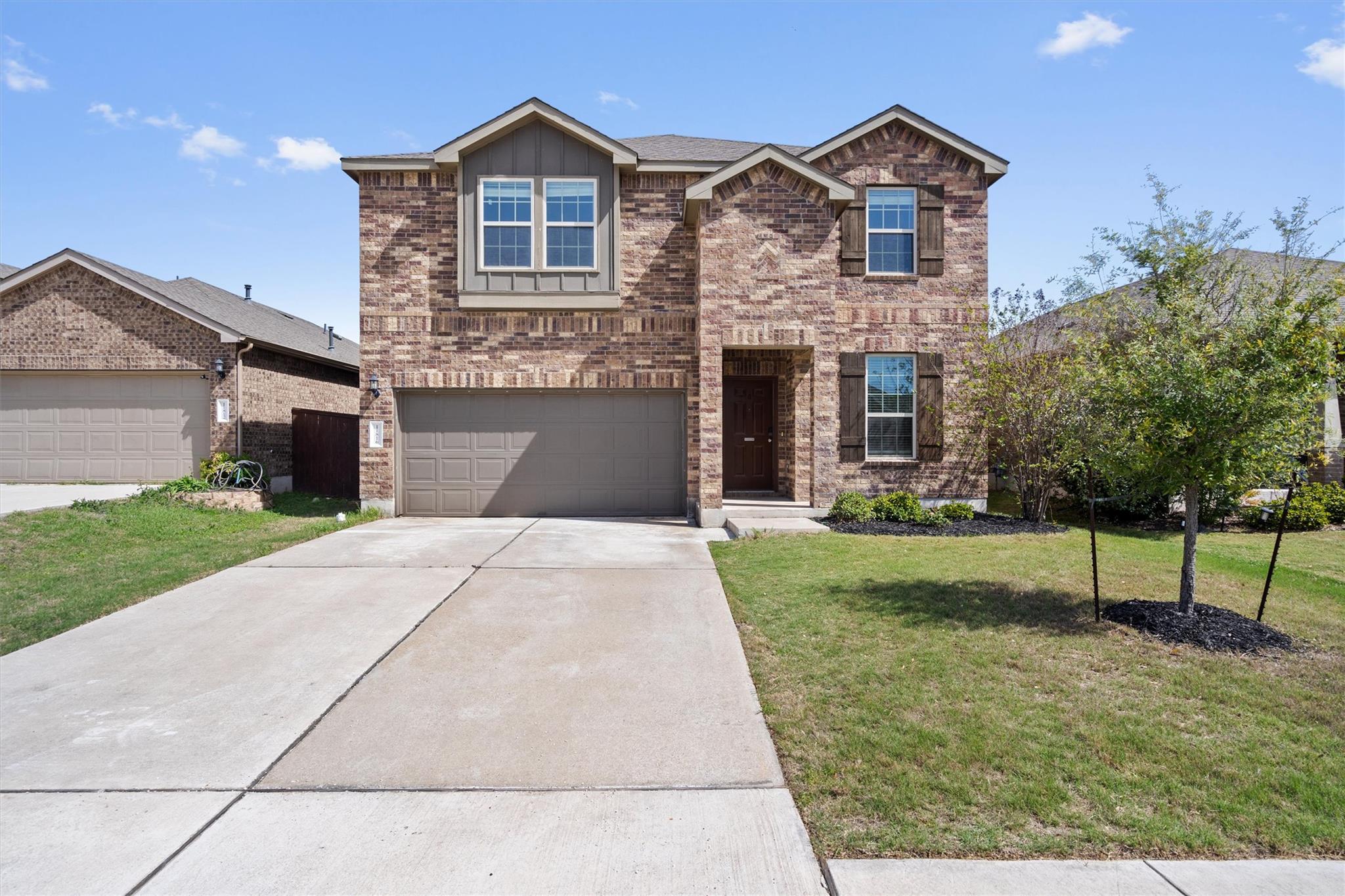 View of front facade with a front lawn, driveway,