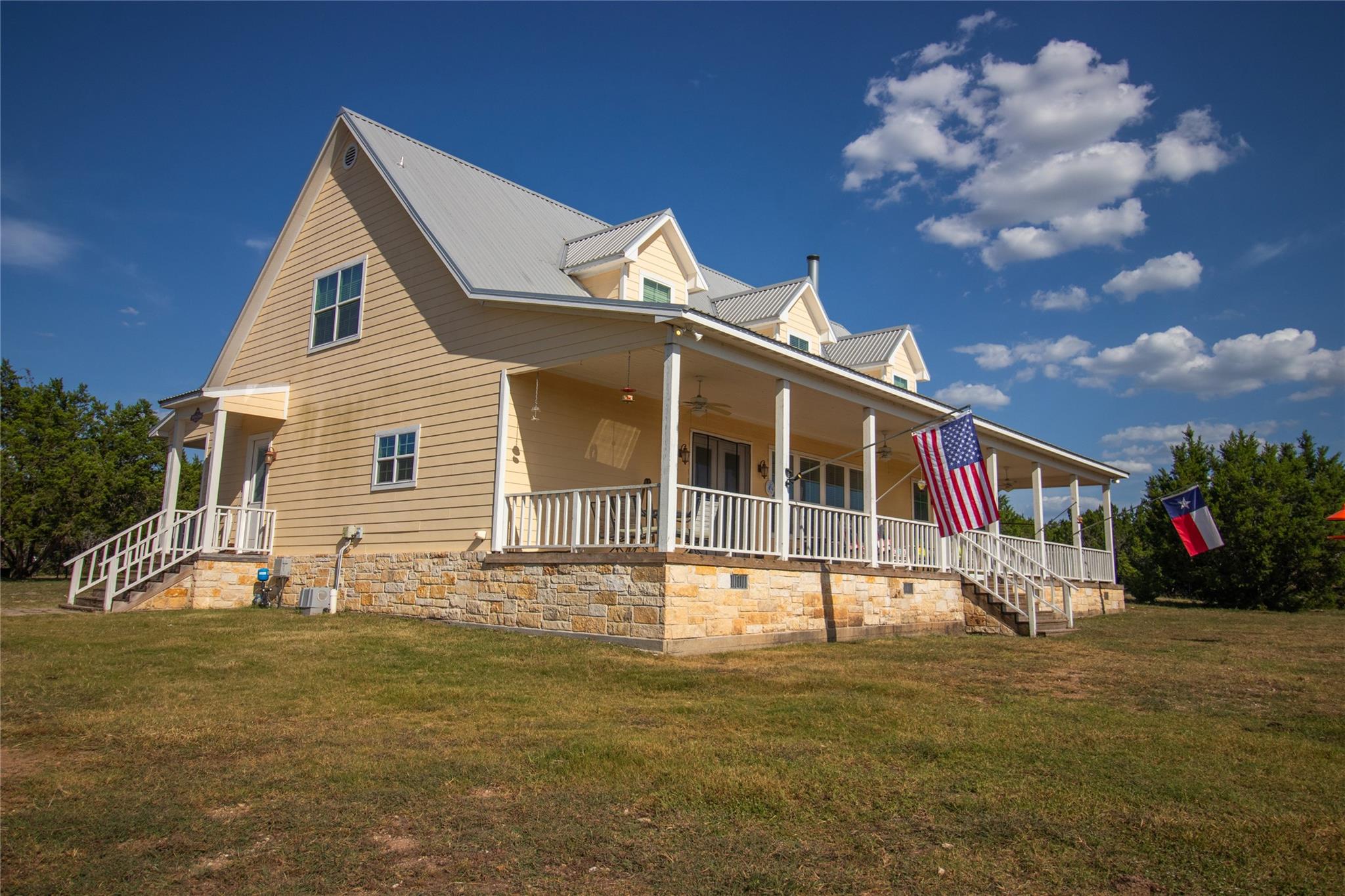 View of side of home with a yard, a porch, a meta