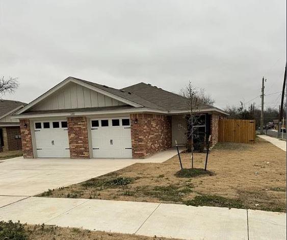 Single story home featuring brick siding, drivewa