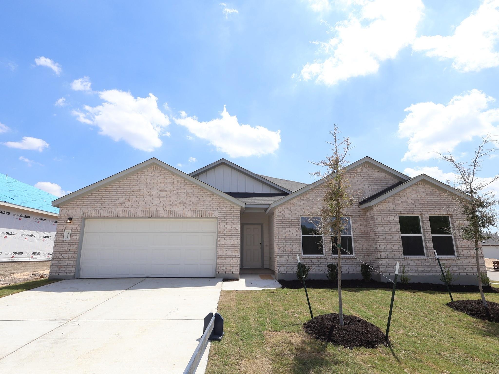 Ranch-style house featuring a garage, driveway, b