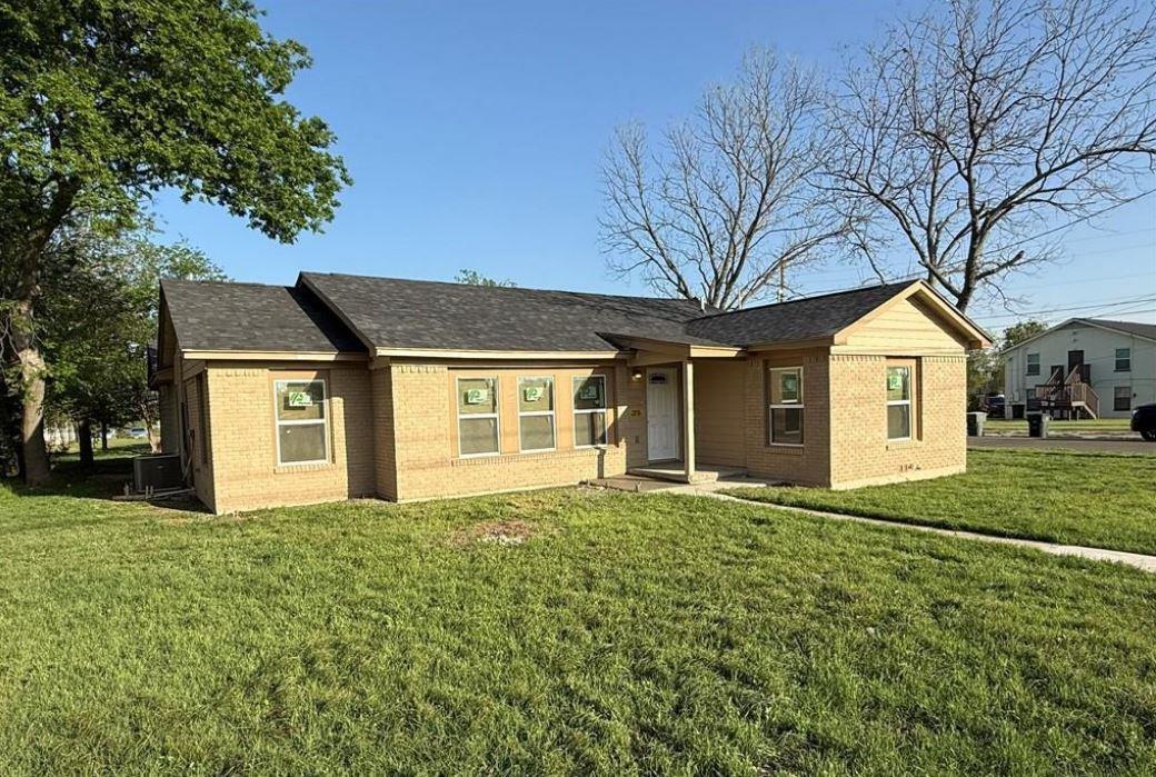 Ranch-style home with a front yard, roof with shi