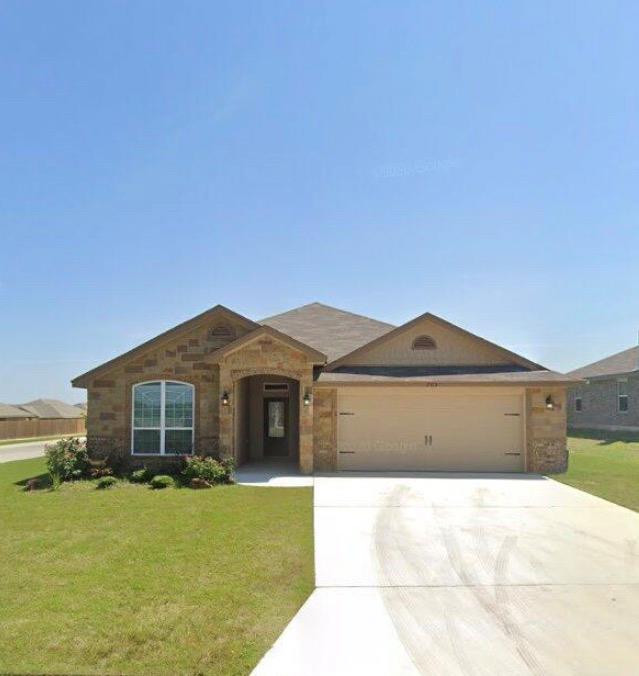Single story home with a front yard, concrete dri