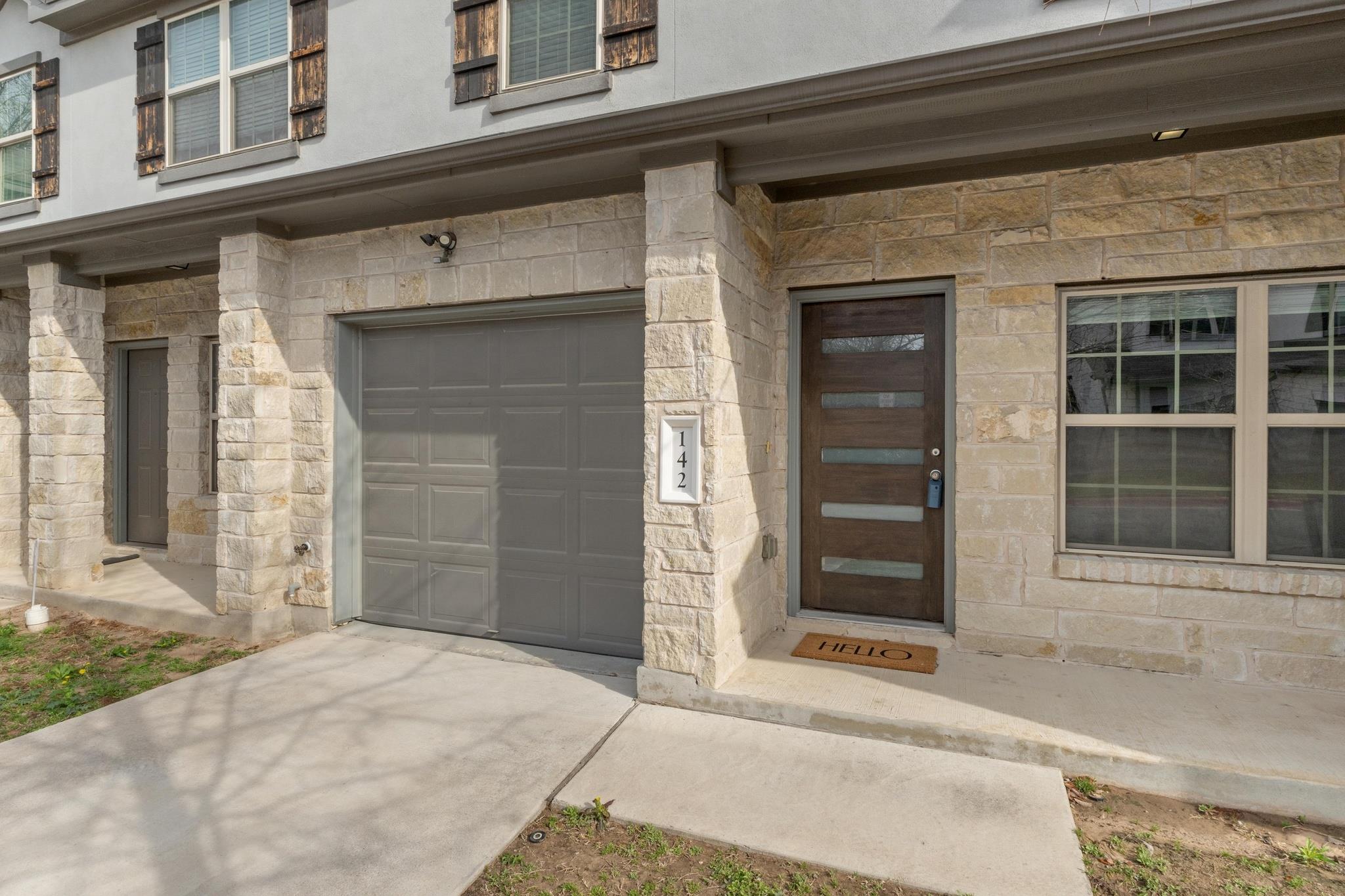 Entrance to property with stone siding, an attach